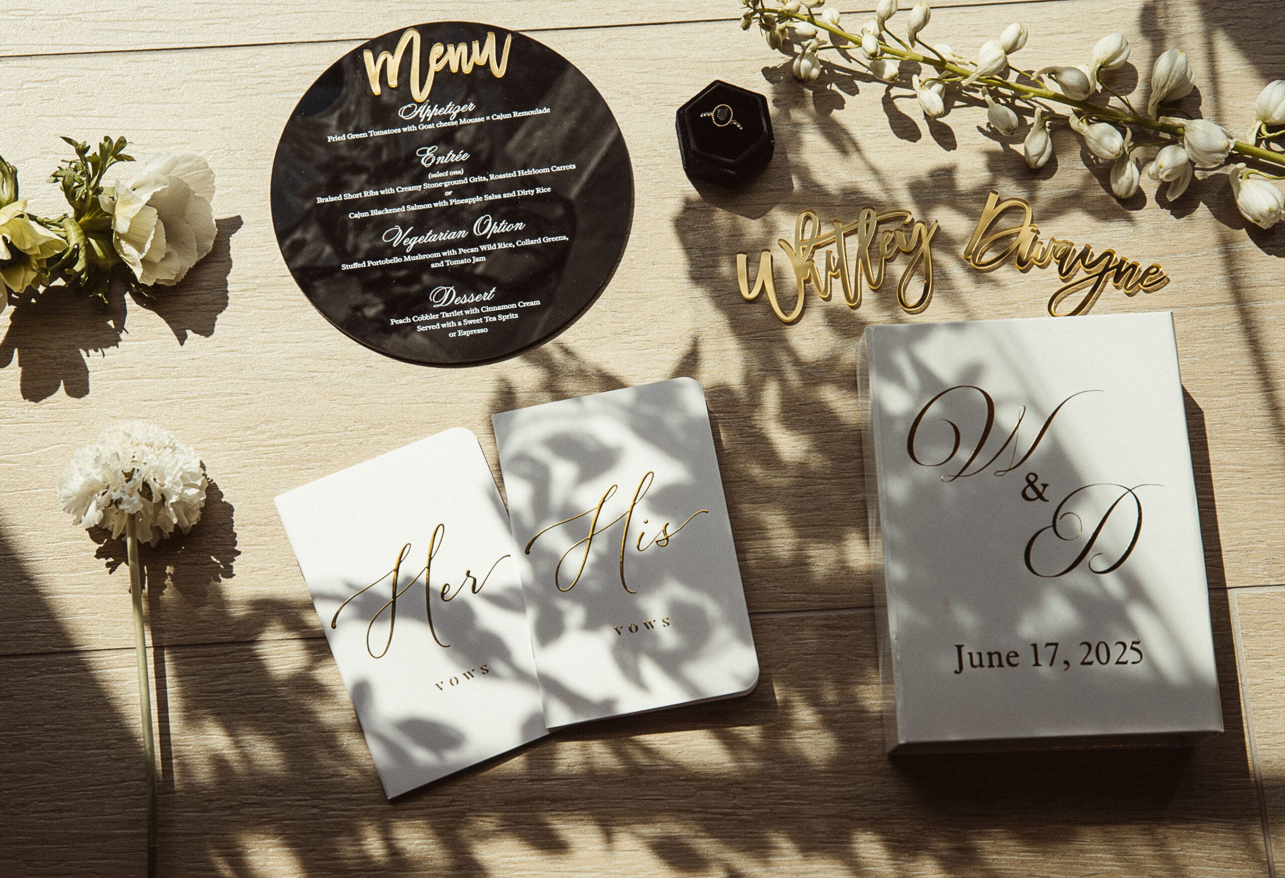 Editorial wedding flatlay featuring personalized vow books, stationary, and golden details,, styled to reflect timeless design and storytelling.