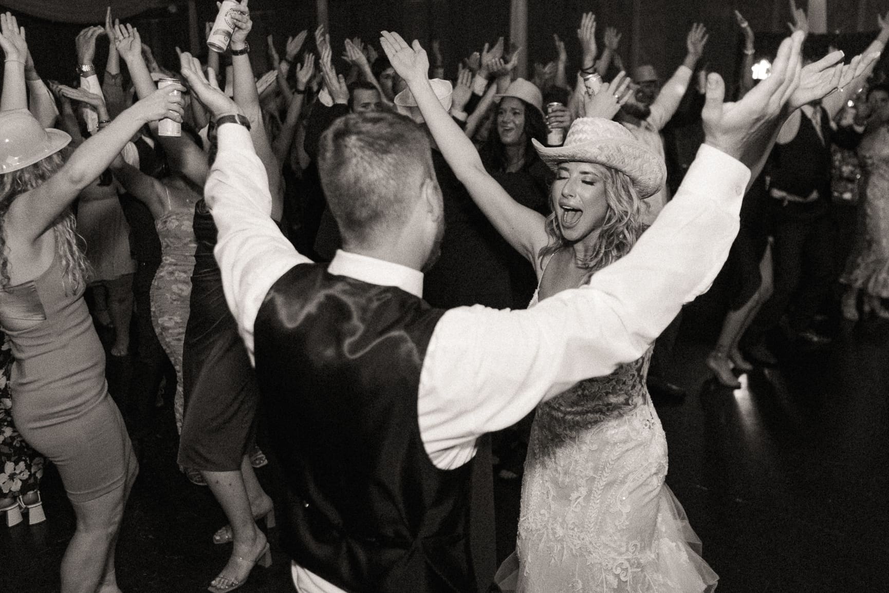 Editorial wedding reception moment of a couple dancing with unfiltered joy, captured in cinematic flash for an effortless, elevated energy. 