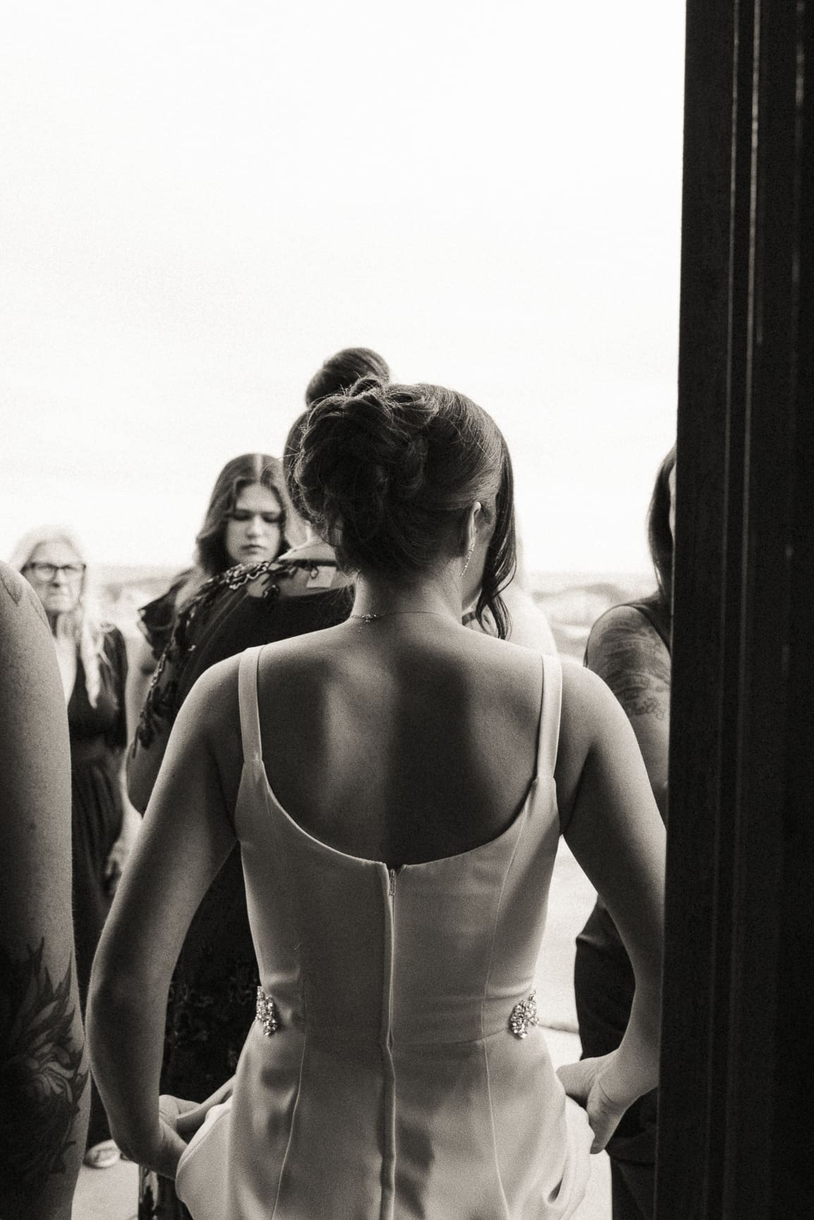 Black and white candid moment of a bride preparing to walk down the aisle, symbolizing emotion and anticipation in editorial wedding photography. 