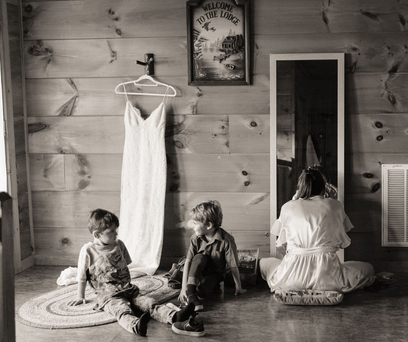 Candid editorial moment of a bride sharing space with two children during wedding morning prep, reflecting intimacy and natural emotion in effortless photography. 