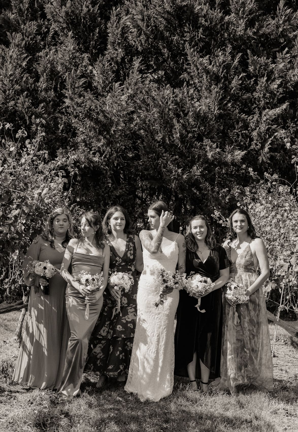 Editorial group portrait of a bride surrounded by her bridesmaids in natural light, showcasing effortless composition and fashion-inspired direction. 