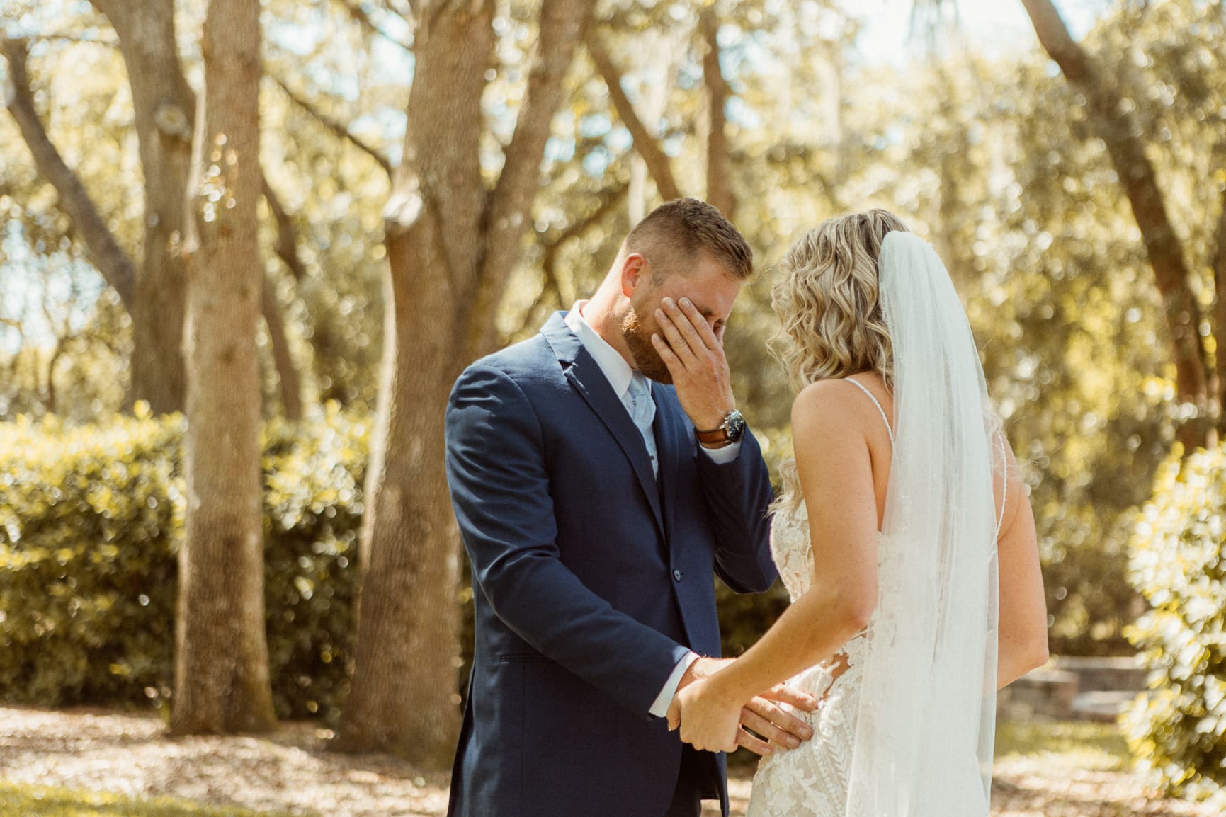 Emotional first look between bride and groom in natural light, captured candidly to reflect the authenticity behind elevated wedding photography.