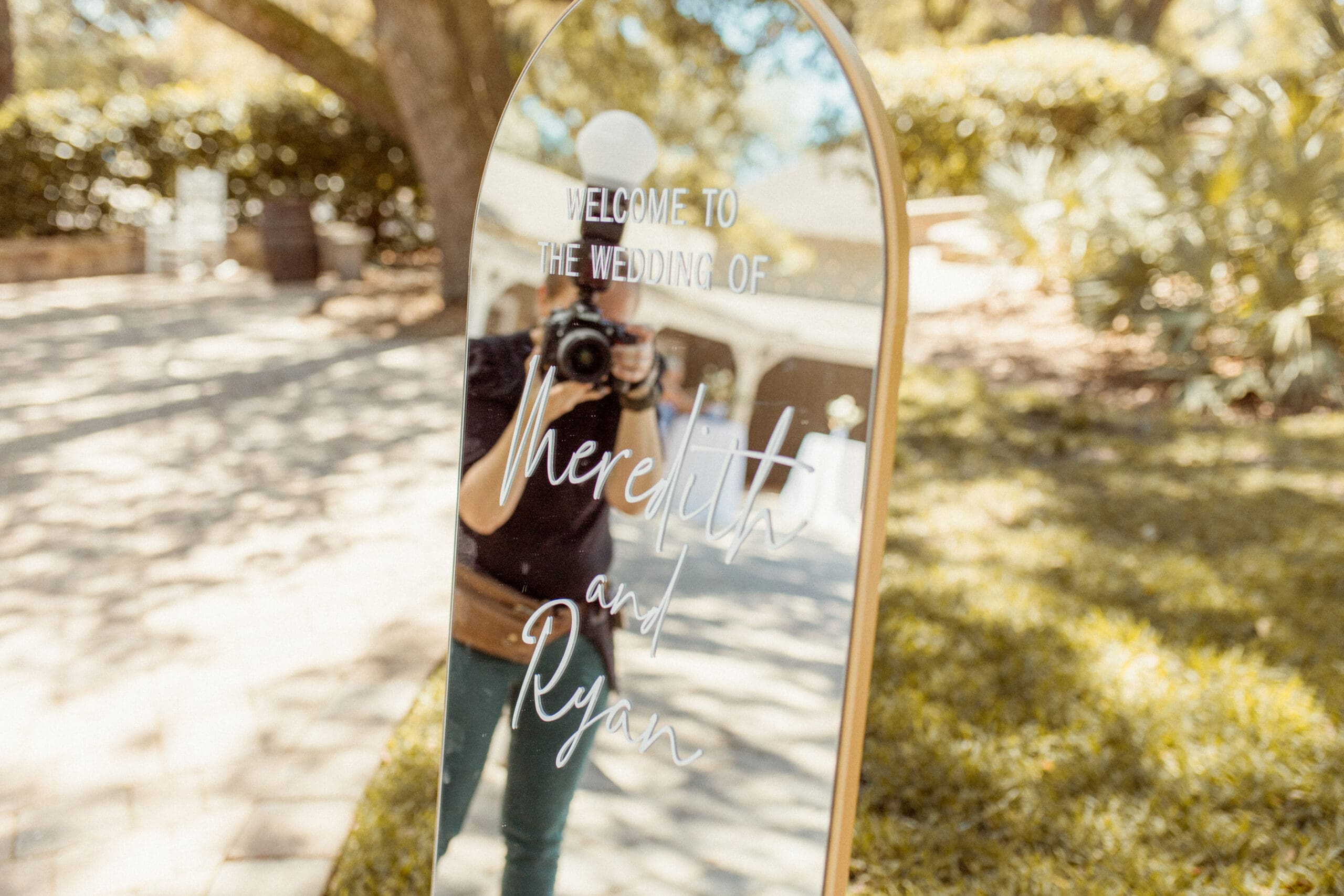 Editorial wedding photographer, Brandi Denslow, taking a behind the scenes selfie in ceremony mirror, showcasing her documentary style during a luxury wedding day.