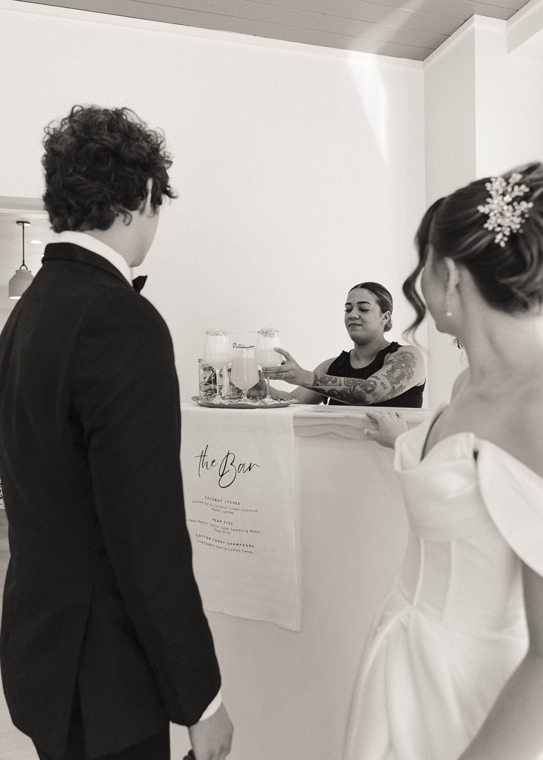 Bride and groom being served cocktails at the Taps Taps mobile bar, black-and-white candid