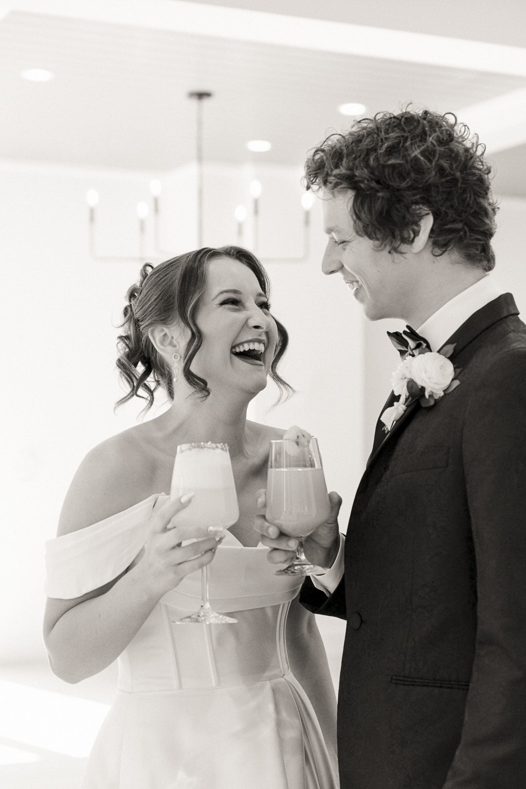 Candid moment between bride and groom laughing with cocktails inside the Old Spanish Quarter- natural, joyful, and editorially lit. 