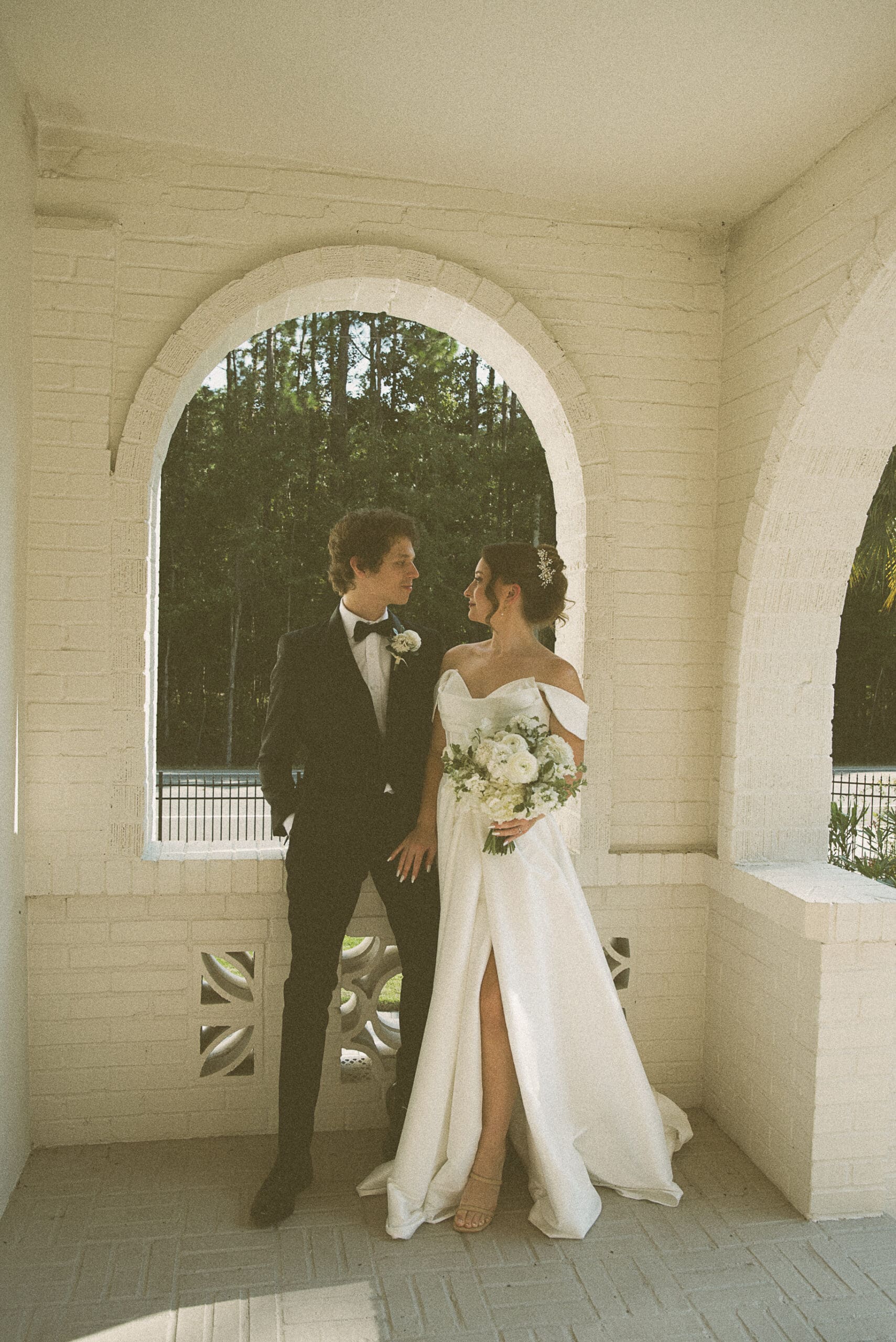Bride and groom embracing under a covered stone archway at the Old Spanish Quarter