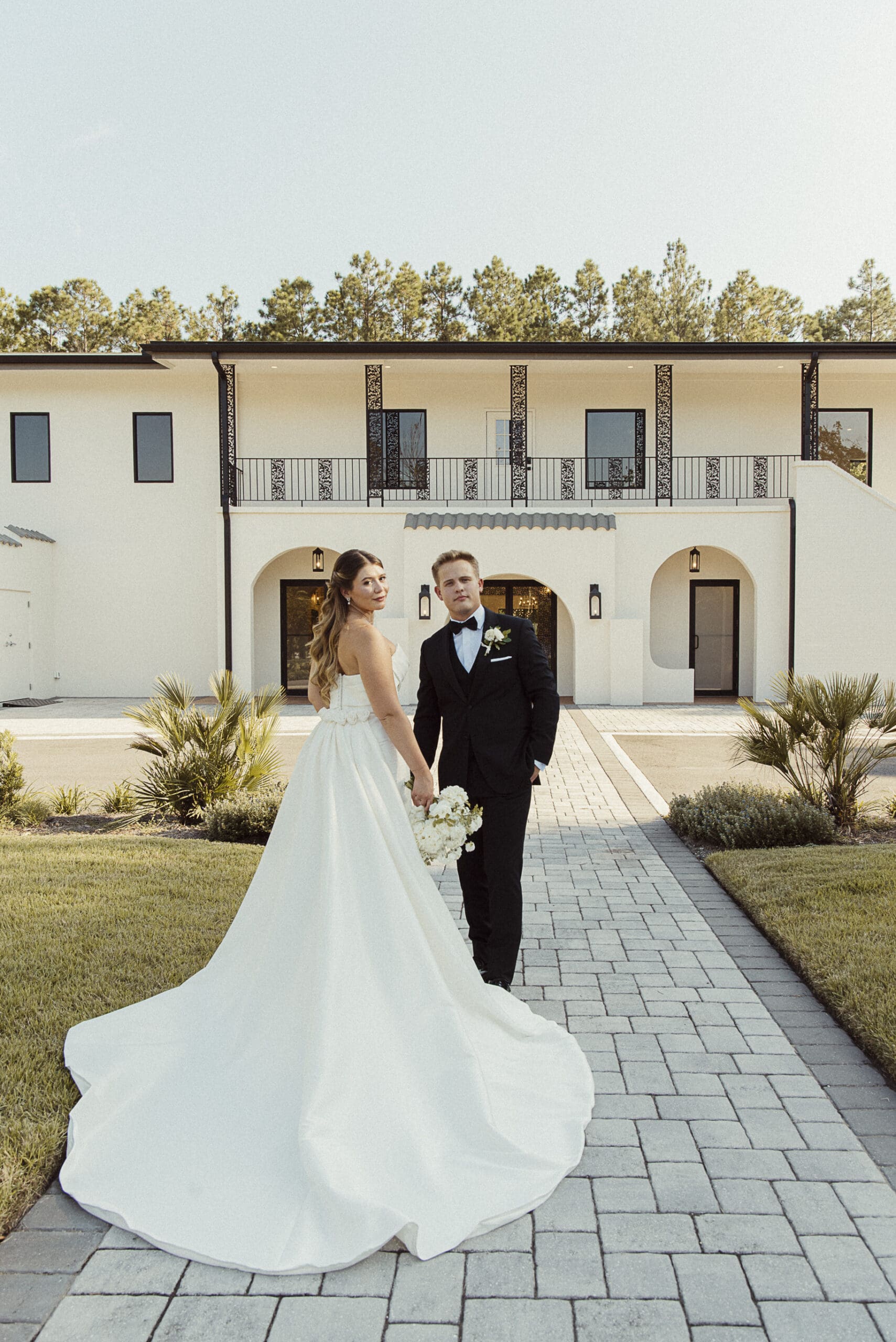 Bride and groom standing before the Old Spanish Quarter's elegant Spanish Revival exterior, blending old-world architecture with a modern, editorial edge.