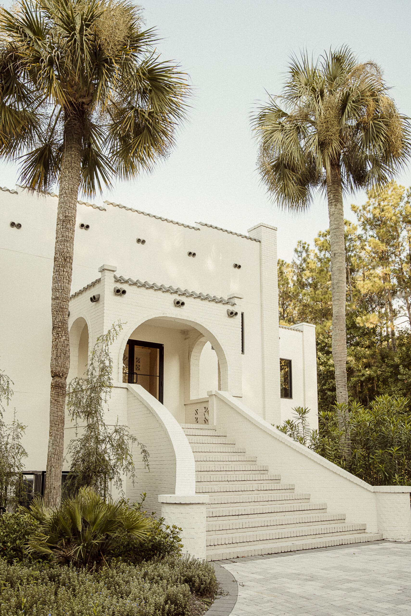 The grand arched staircase and white brick facade of the Old Spanish Quarter in Jacksonville, Florida- a Spanish Revival wedding venue with modern sophistication.