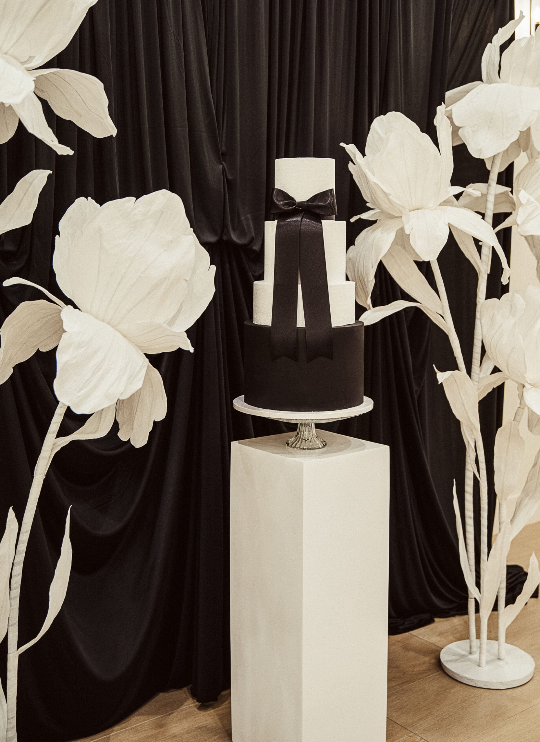 Black tiered wedding cake with satin ribbon, styled for an editorial wedding at the Old Spanish Quarter