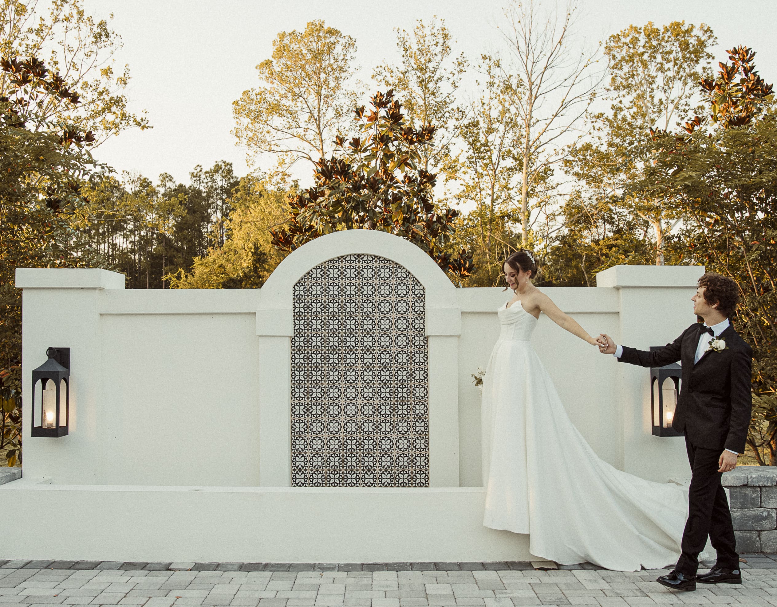 Bride and groom framed by the Spanish tile wall and arched courtyard of the Spanish Quarter, capturing the venue's timeless charm and artistry.