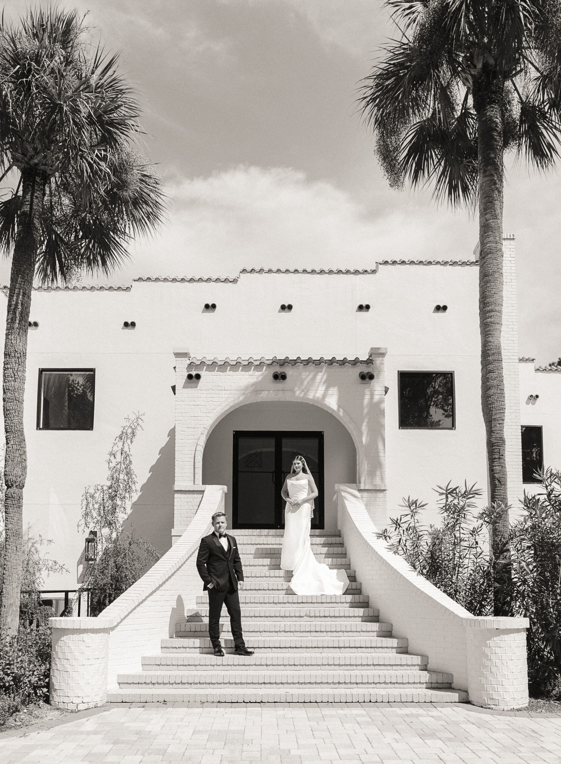 Black-and-white portrait of the couple on the venue's grand staircase