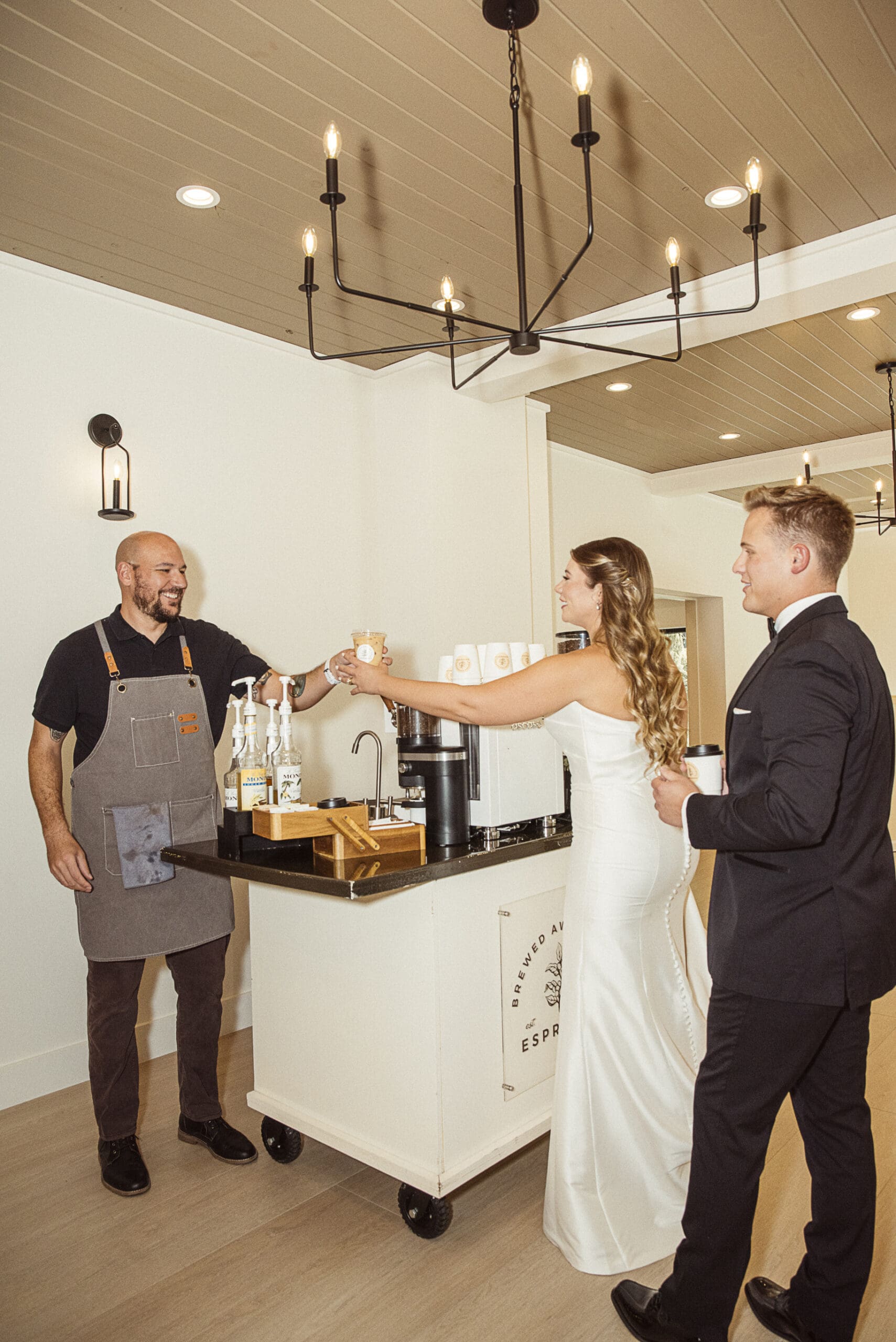 Bride and groom ordering drinks at the Brewed Awakening coffee cart during the reception