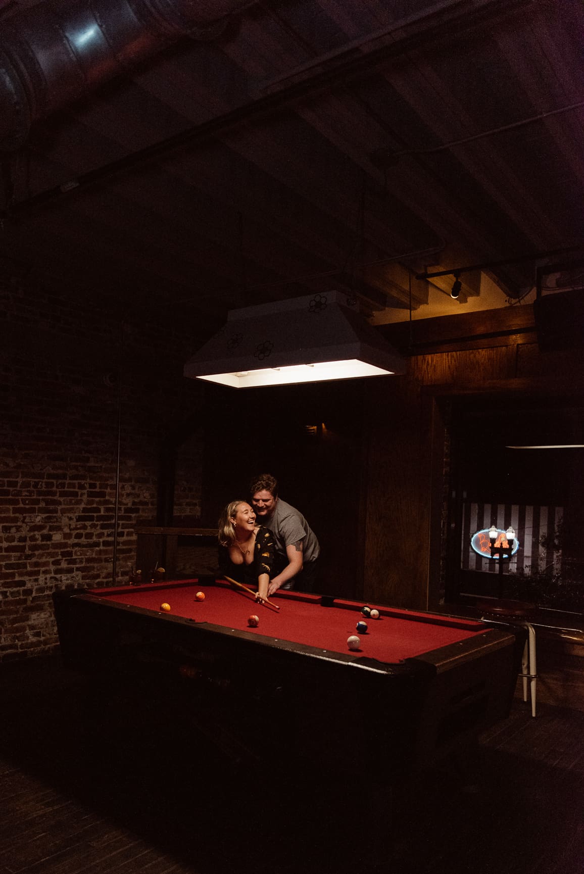 Couple enjoying a relaxed moment at a pool table bar during their St. Augustine wedding weekend.