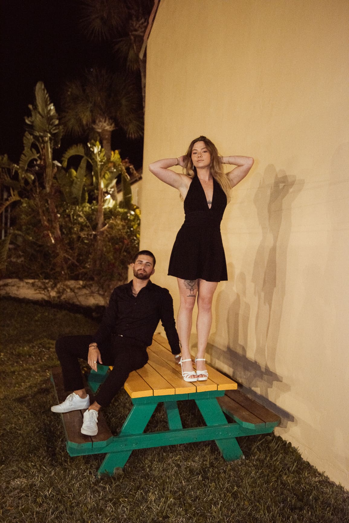 Editorial-style engagement portrait of a couple styled in intentional fashion and photographed at night, demonstrating how creatively directed engagement sessions prioritize vibe and confidence. 