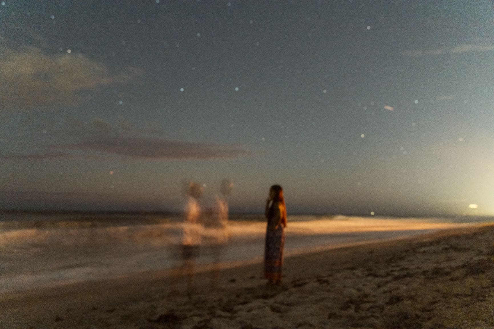 Artistic engagement photo using motion blur and low light on the beach, showing how creatively directed engagement sessions focus on emotion, movement, and story over traditional posing