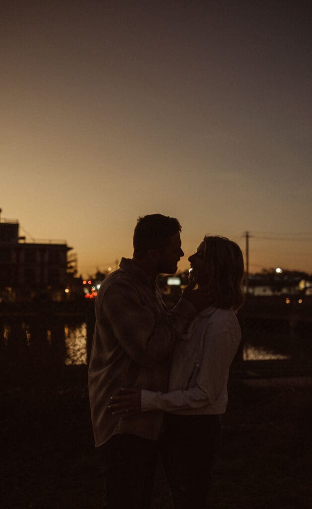 Cinematic engagement photos in St. Augustine at sunset capturing an intimate silhouette ofa. couple by the water.