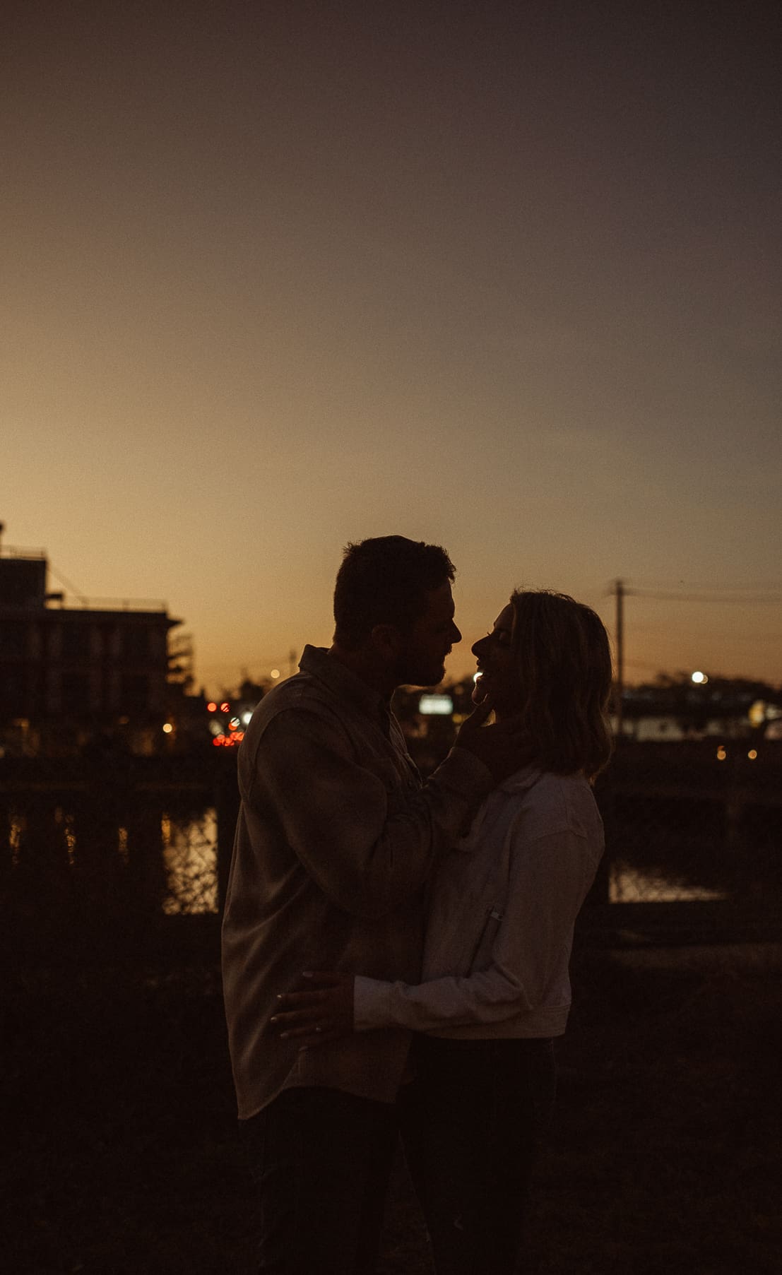 Cinematic engagement photos in St. Augustine at sunset capturing an intimate silhouette ofa. couple by the water. 