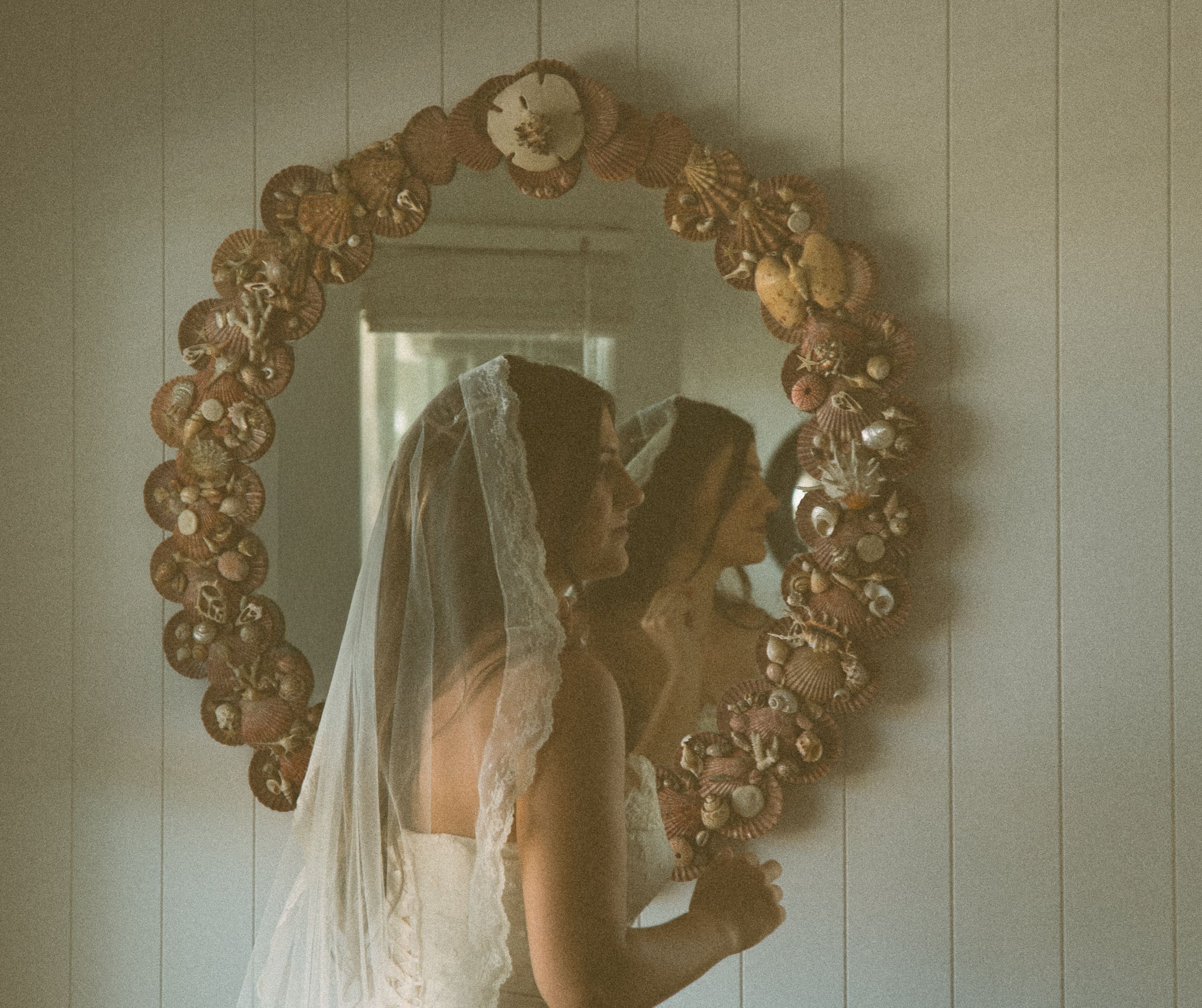 Bride walks by shell mirror quietly before ceremony begins. 