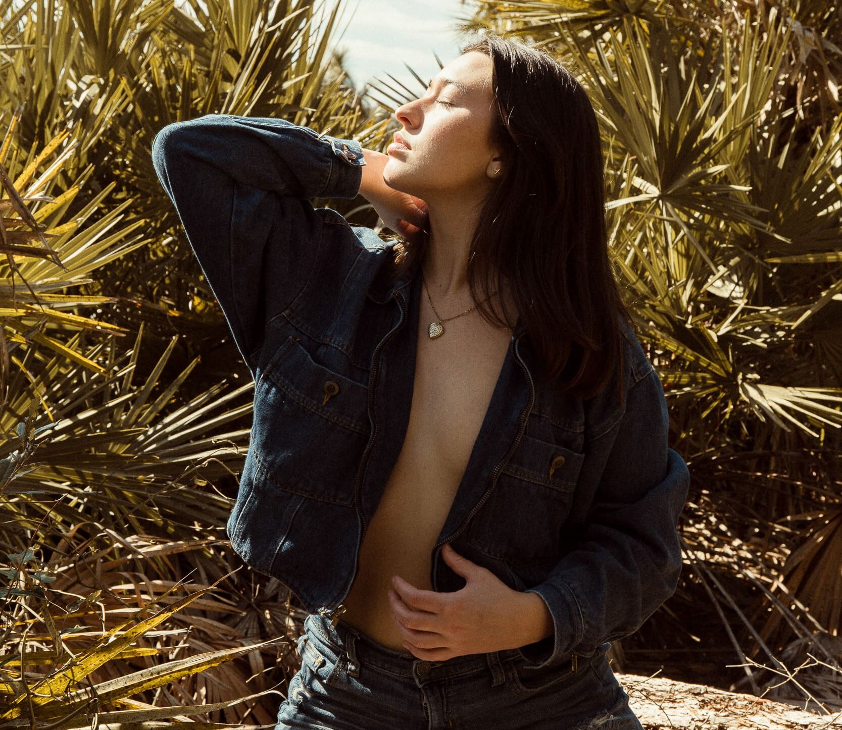 Woman standing in golden light during an embodiment photography session, eyes closed and feeling grounded and at ease in her body