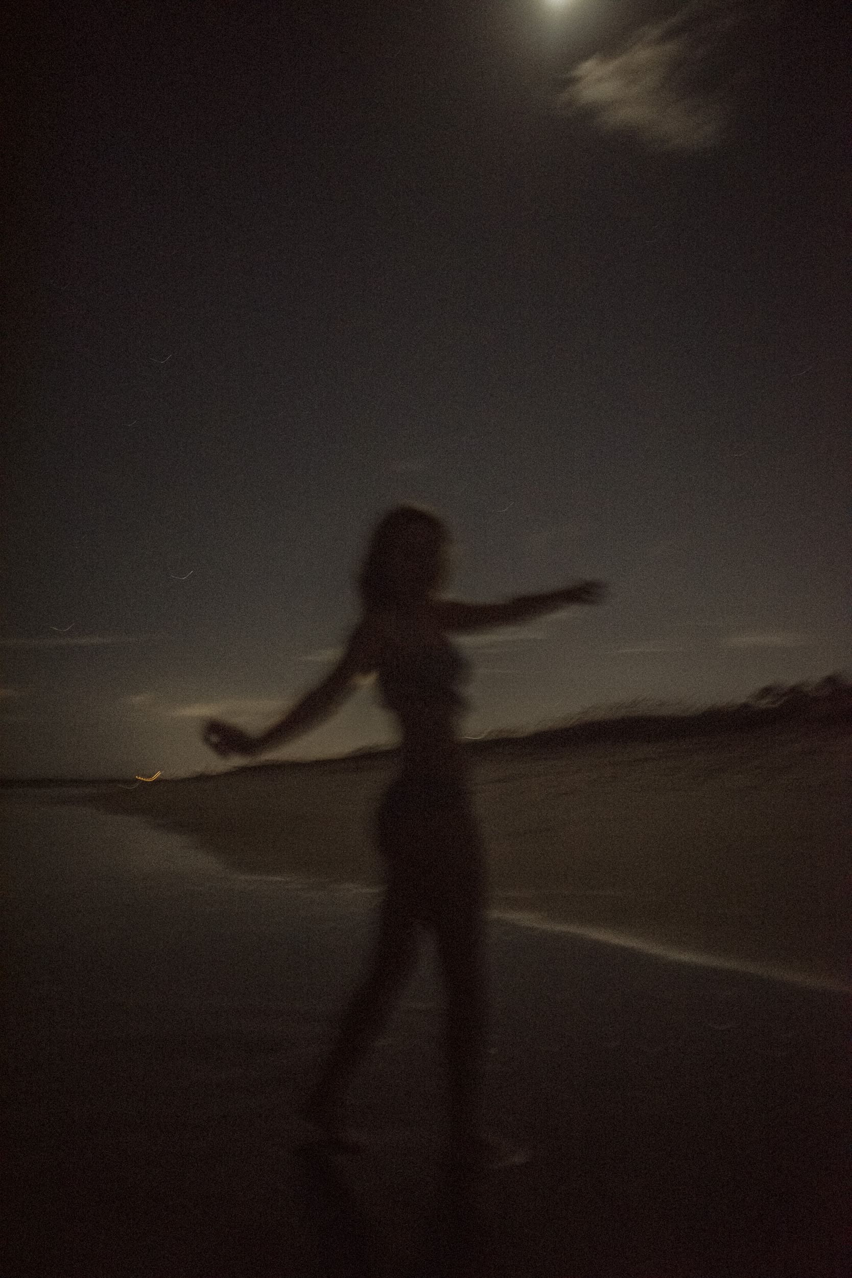Blurred silhouette of a woman moving freely outdoors during an embodiment photography session, capturing emotional release, movement, and presence. 