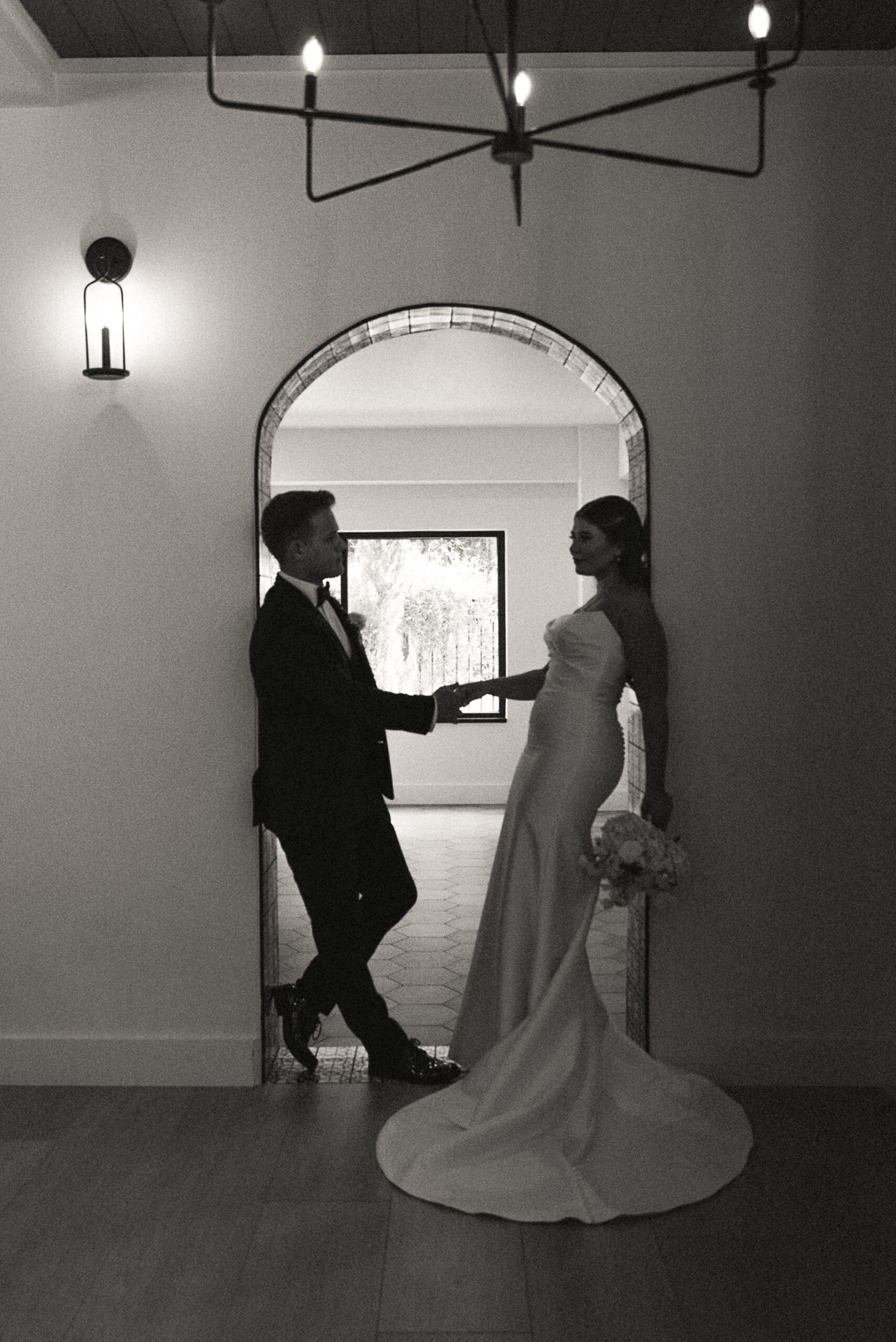 Romantic bride and groom portrait framed by an arched window in St. Augustine.