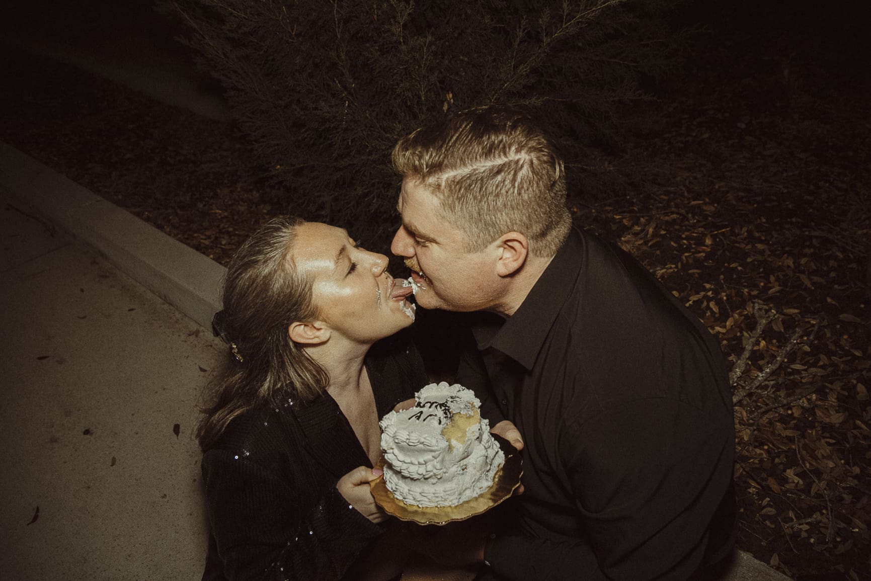 Bride and groom playfully feeding each other cake during a non traditional wedding celebration in St. Augustine, Florida