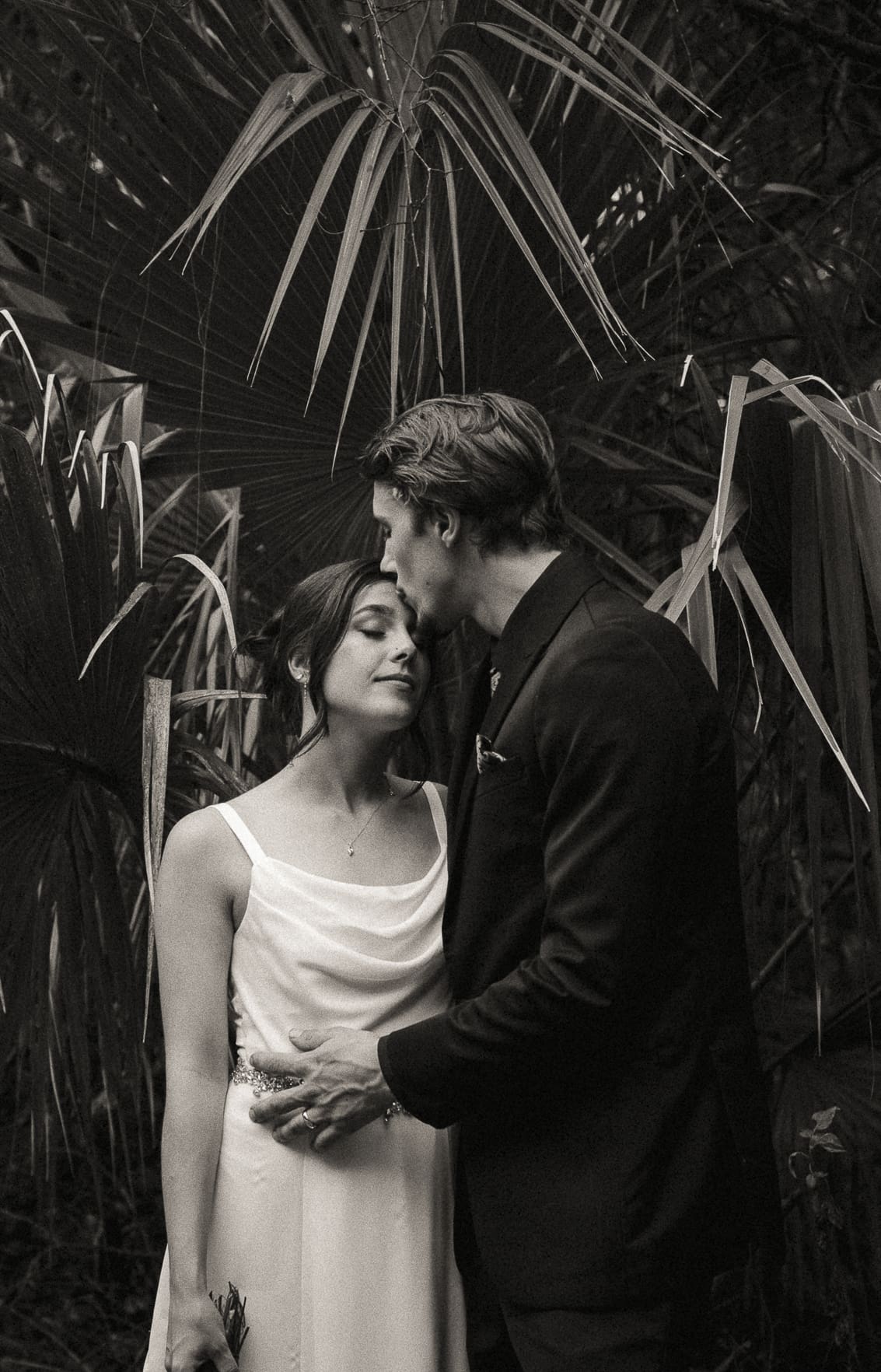 Romantic lack and white wedding portrait of couple in lush greenery in St. Augustine Florida.