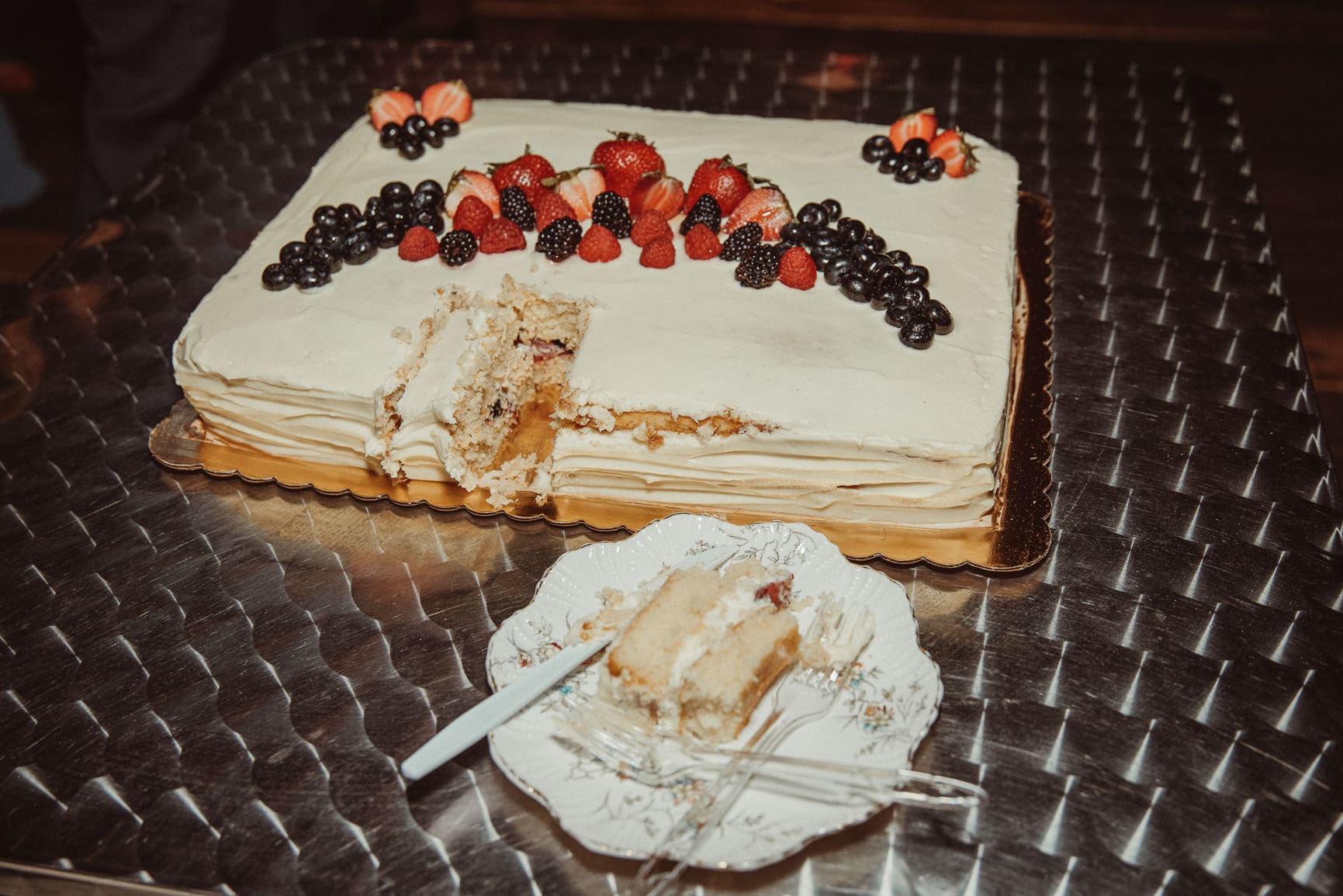 Partially cut wedding cake with fresh berries at a non traditional wedding reception in St. Augustine, Florida