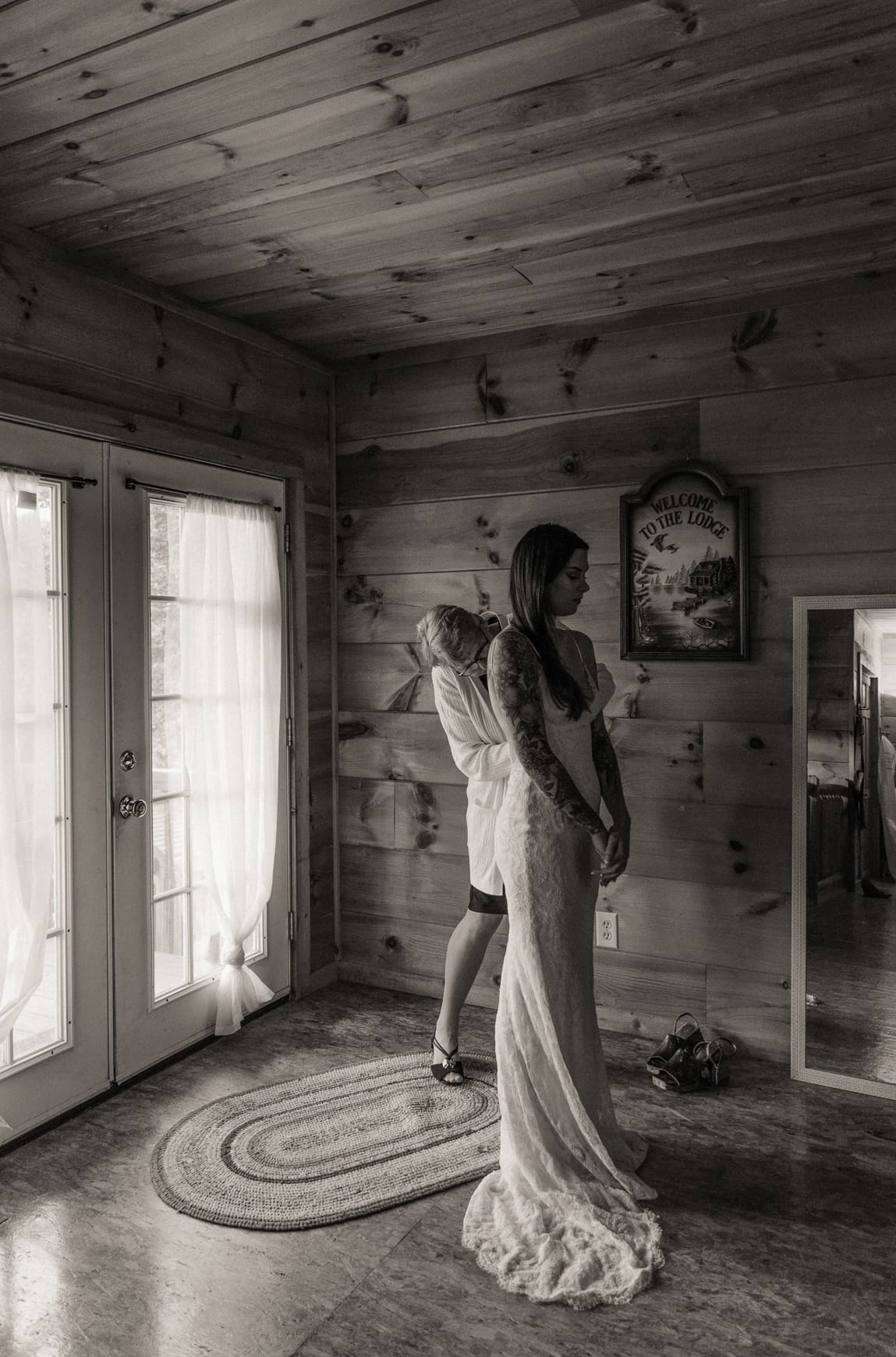 A bride getting dressed near a window with subtle direction from her photographer to create natural, flattering light. 