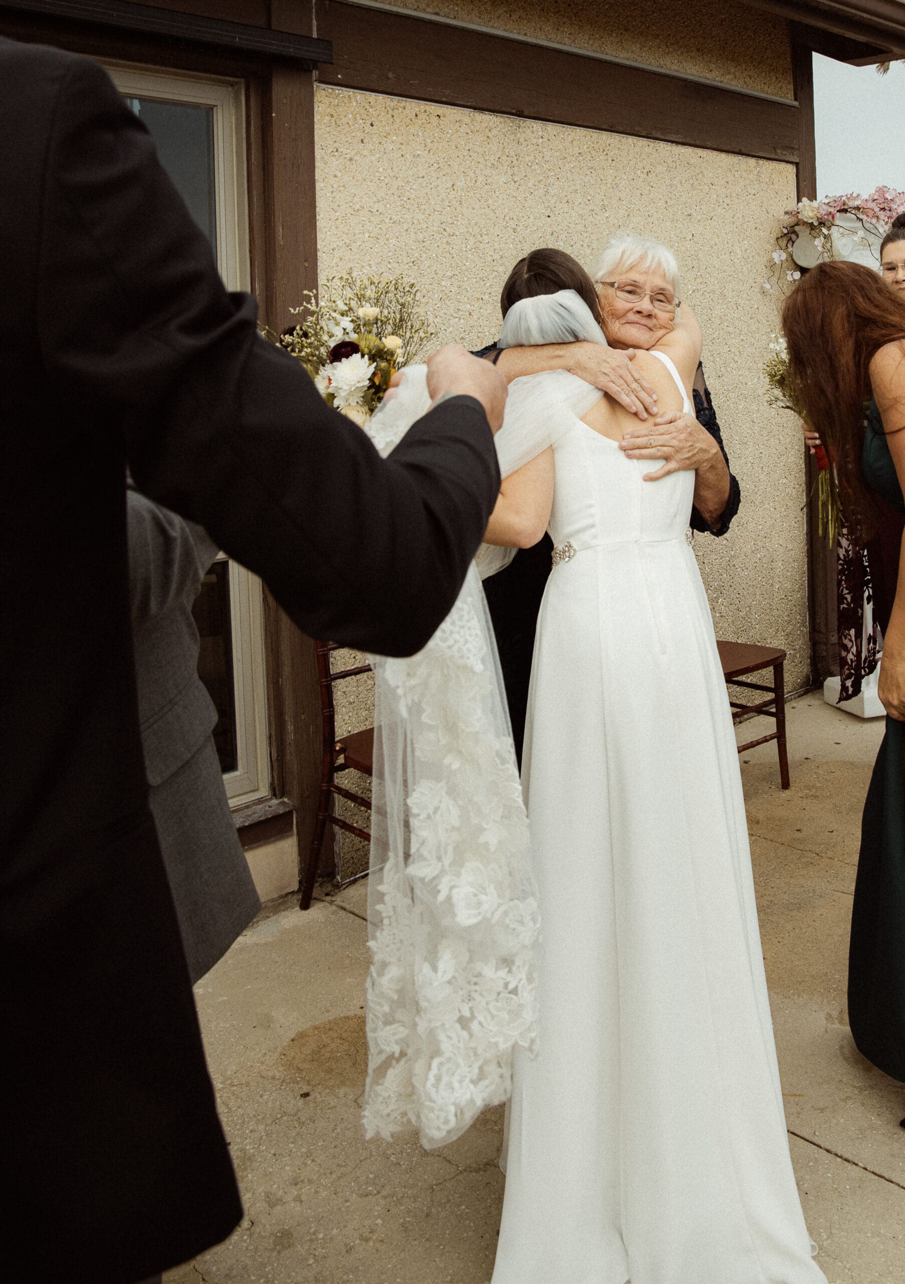 An emotional embrace between a bride and a loved one, captured naturally without posing during a wedding day