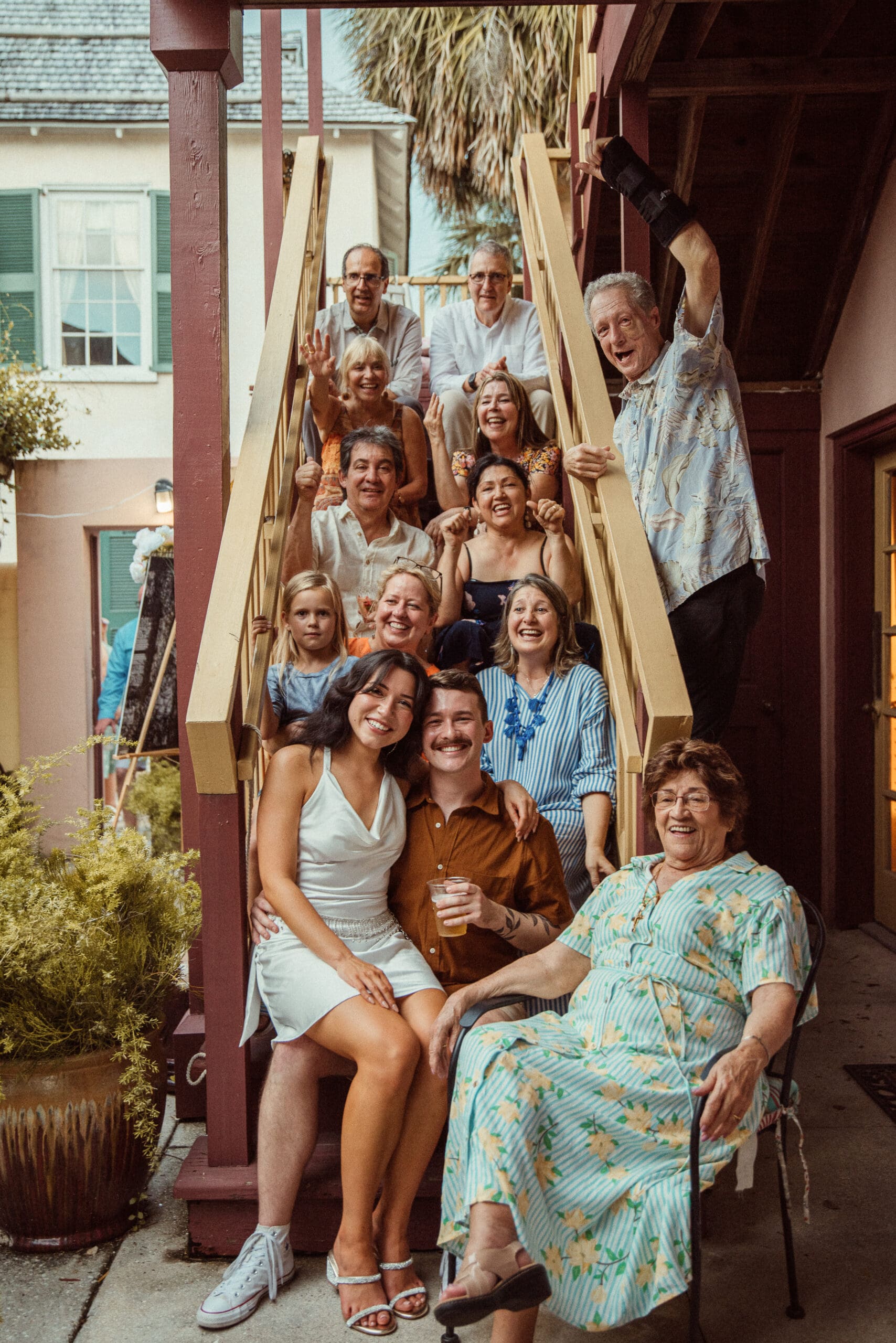 Large extended family portrait gathered on outdoor stairs during a St. Augustine wedding weekend celebration.