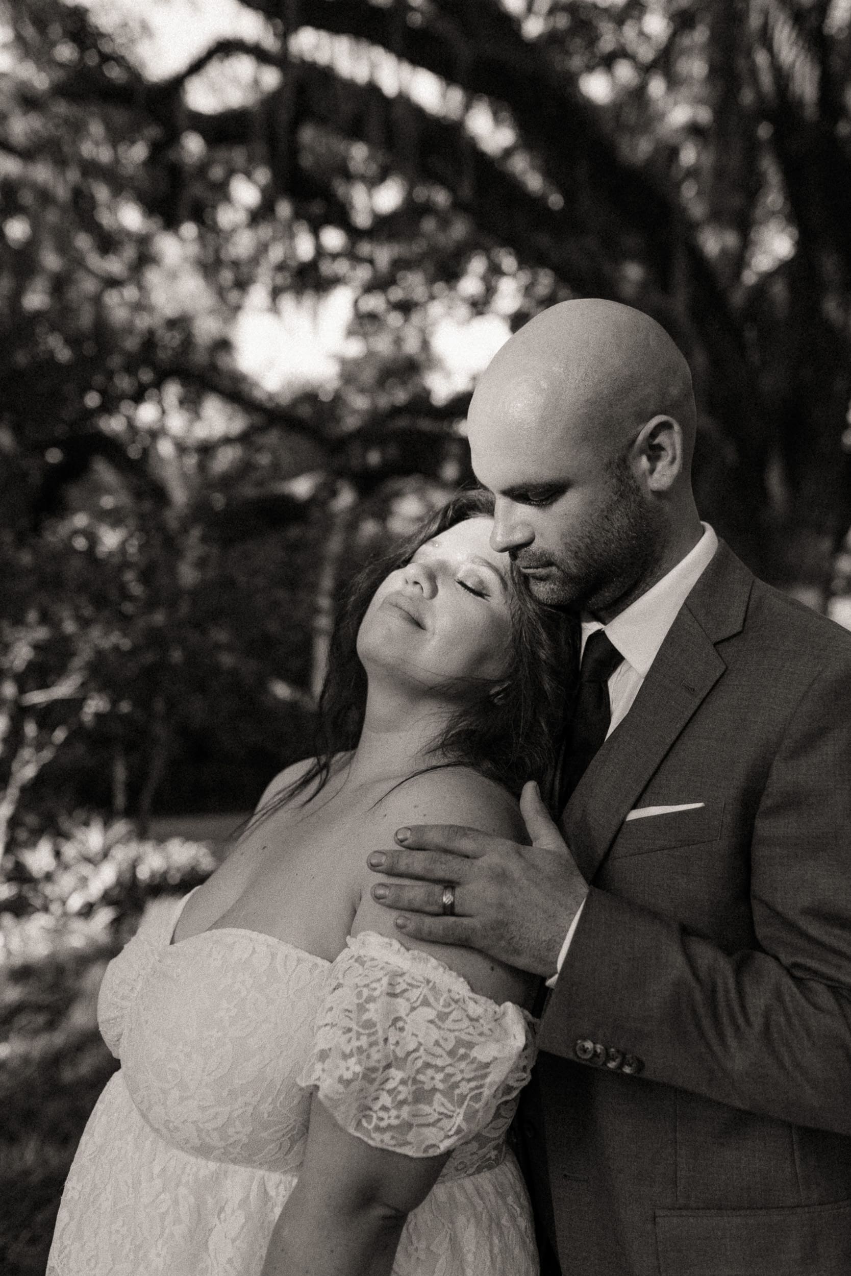 Romantic couple portrait beneath oak trees during an intimate St. Augustine wedding celebration.