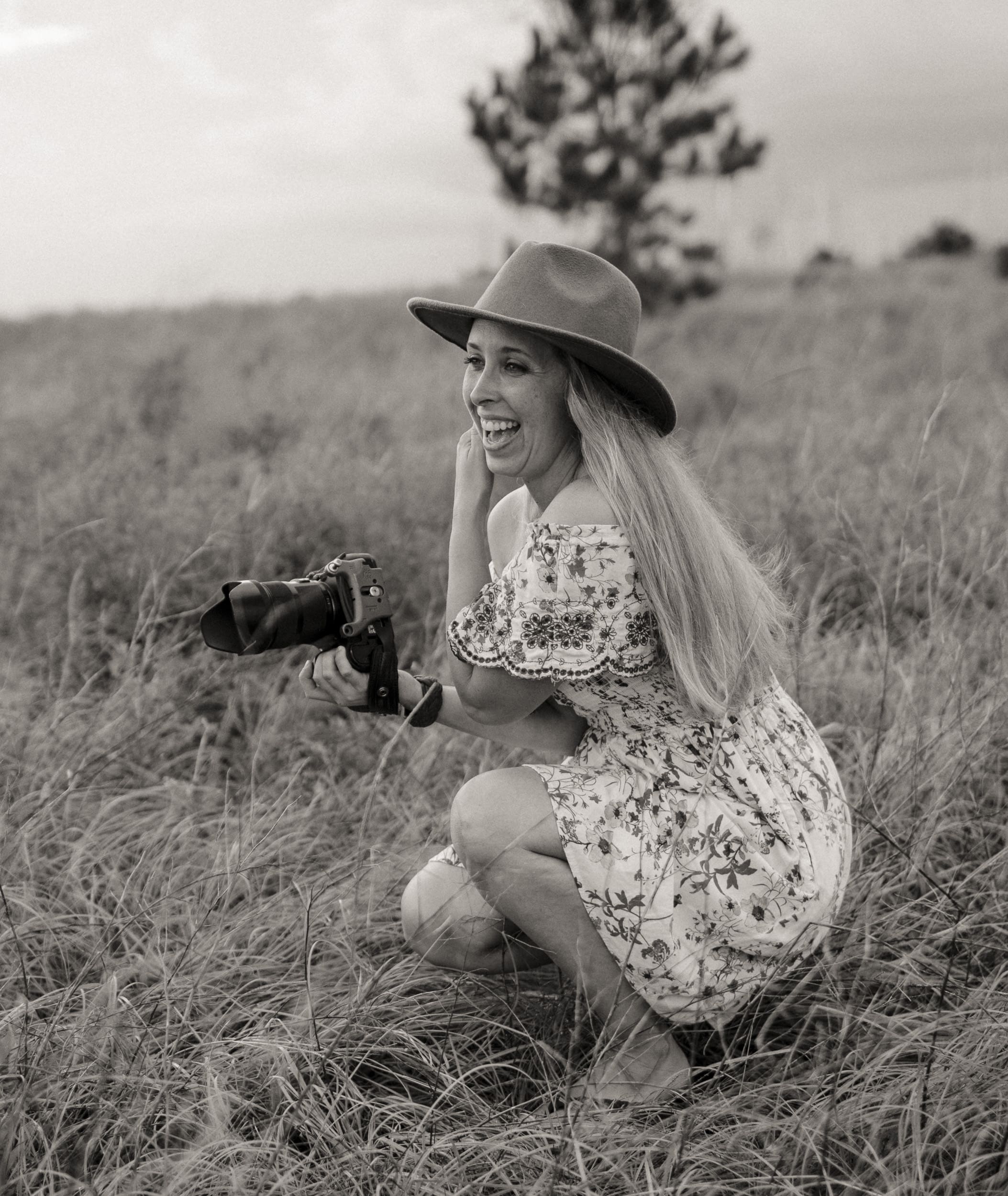 St. Augustine photographer Brandi Denslow laughing while photographing a session, capturing candid connection and ease behind the camera