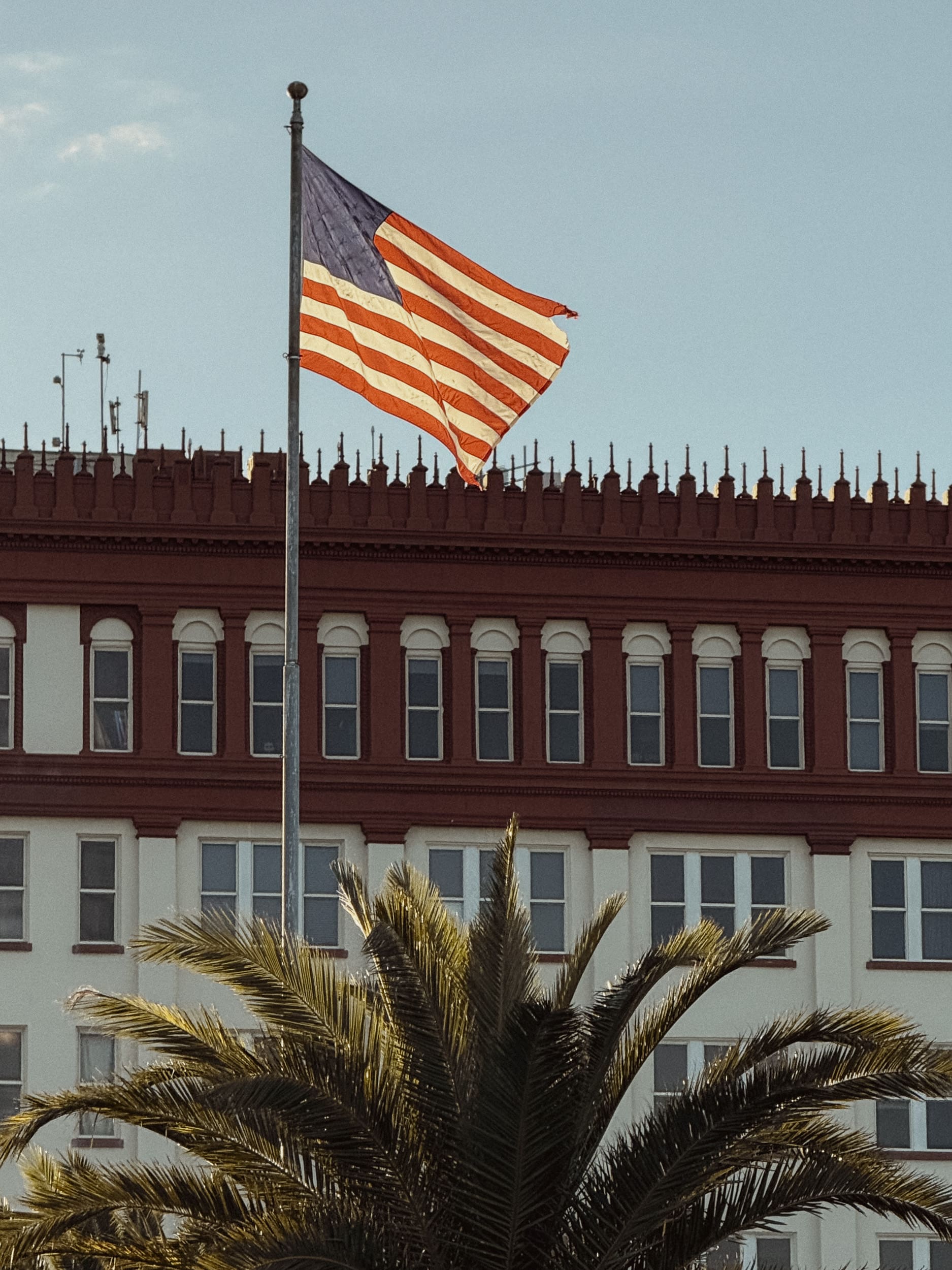 American flag flying above historic St. Augustine architecture with a palm tree below, photographed from a child’s perspective during a downtown photo walk.