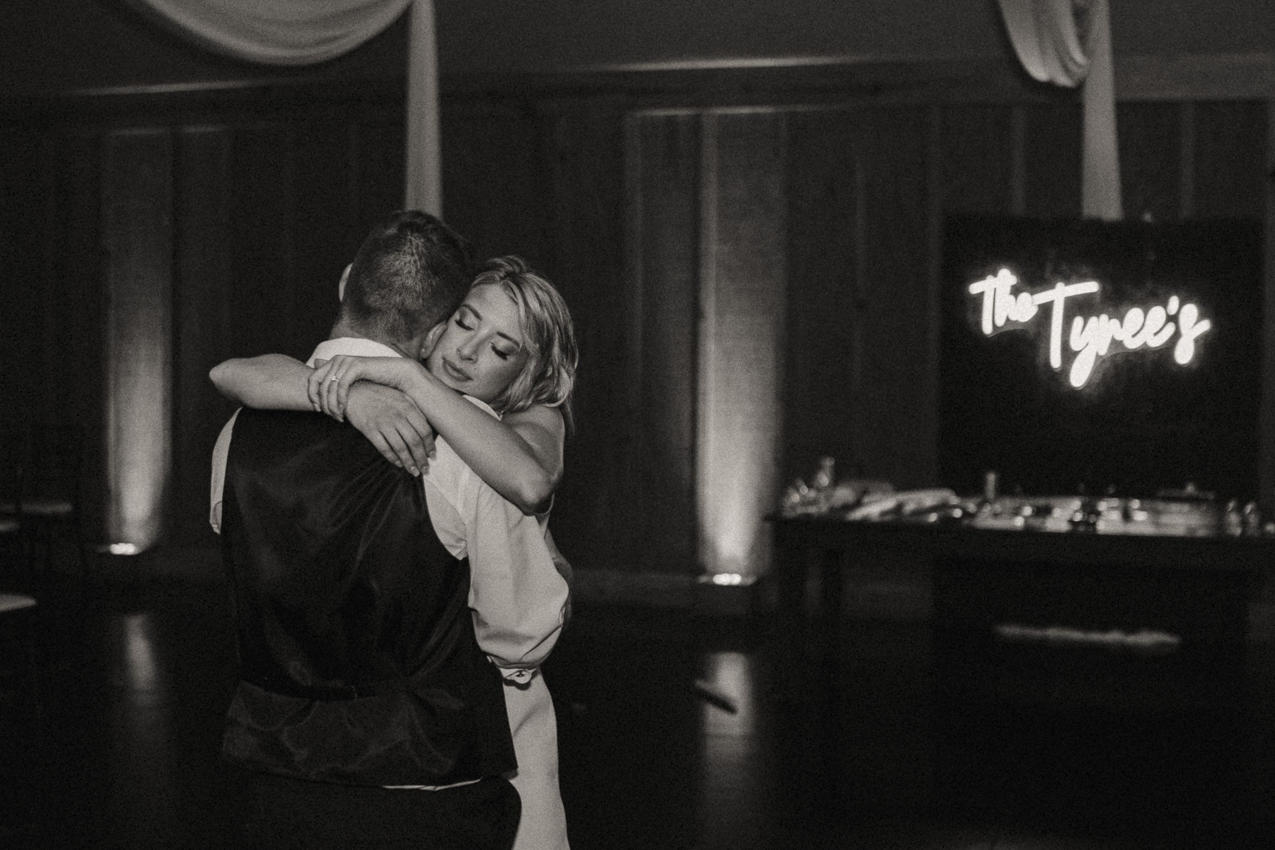 A couple embracing during their last dance, photographed with an artistic and documentary wedding photography approach