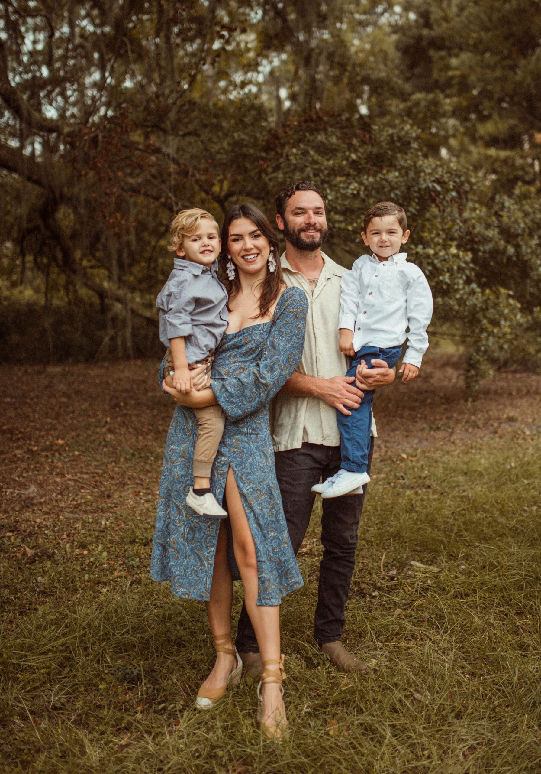 Family of four wearing coordinated blue and neutral outfits during outdoor St. Augustine family photo session
