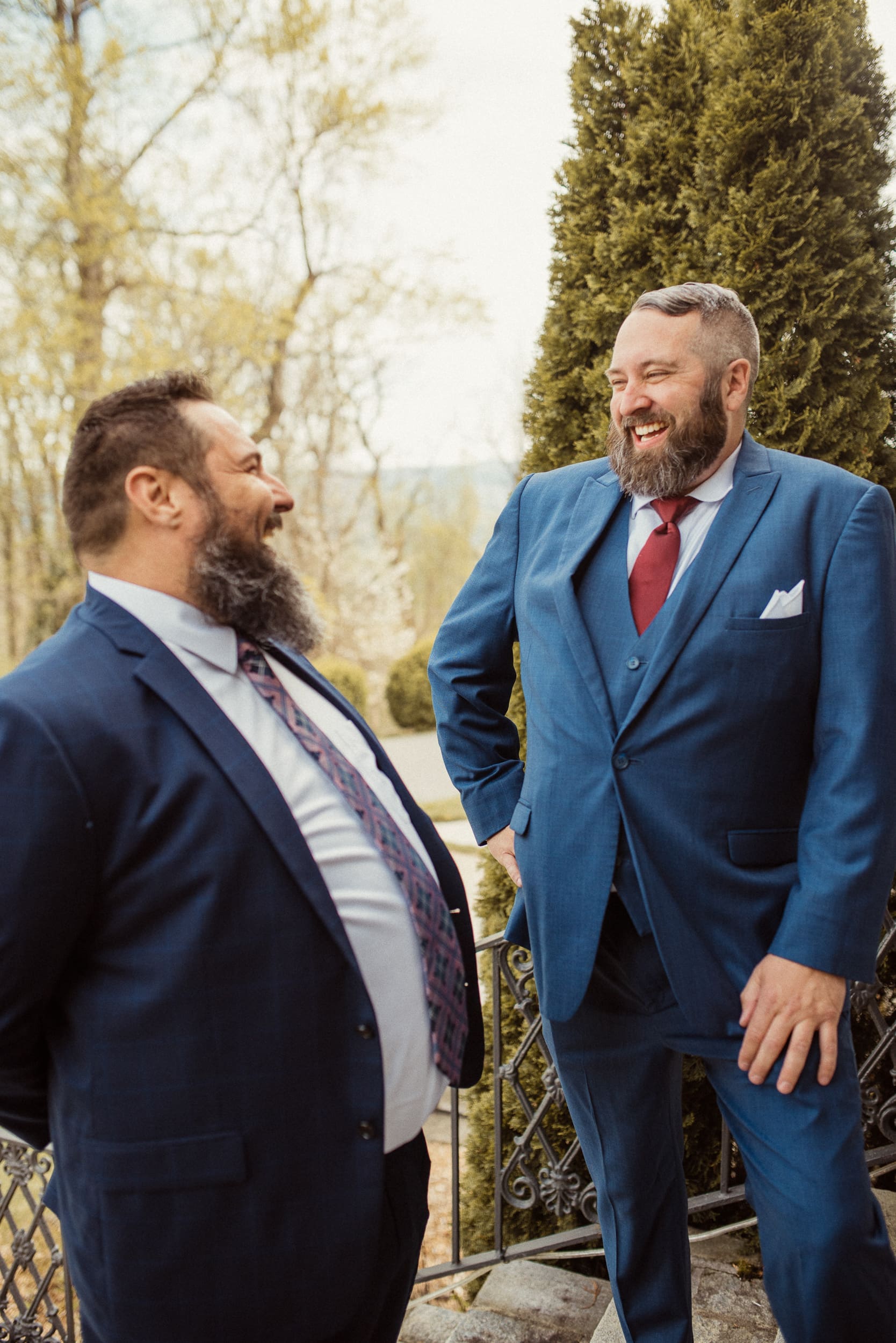 Groom laughing with friend before ceremony at intimate North Carolina mountain wedding. 
