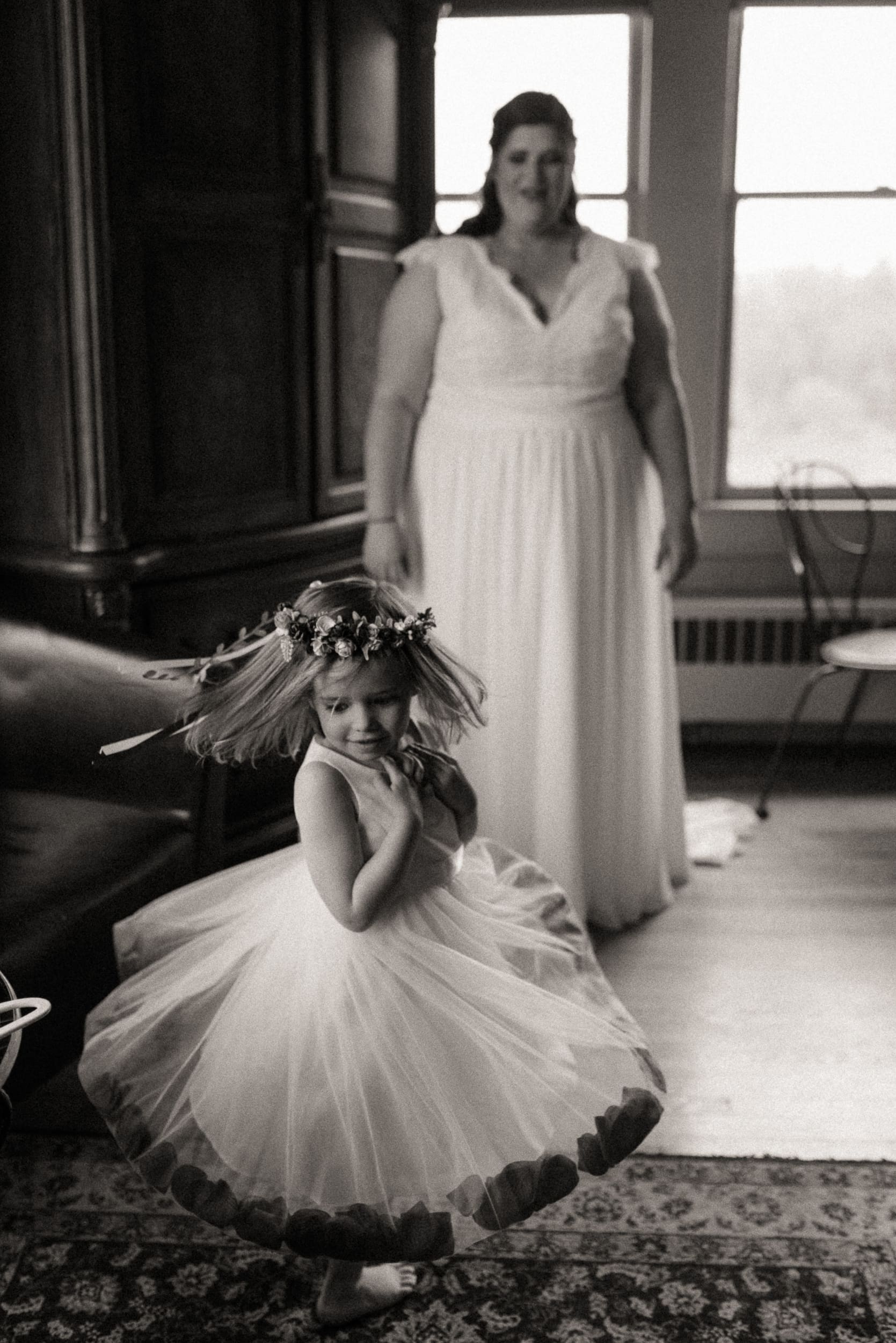 Young girl twirling in dress while bride watches during intimate wedding morning in North Carolina. 
