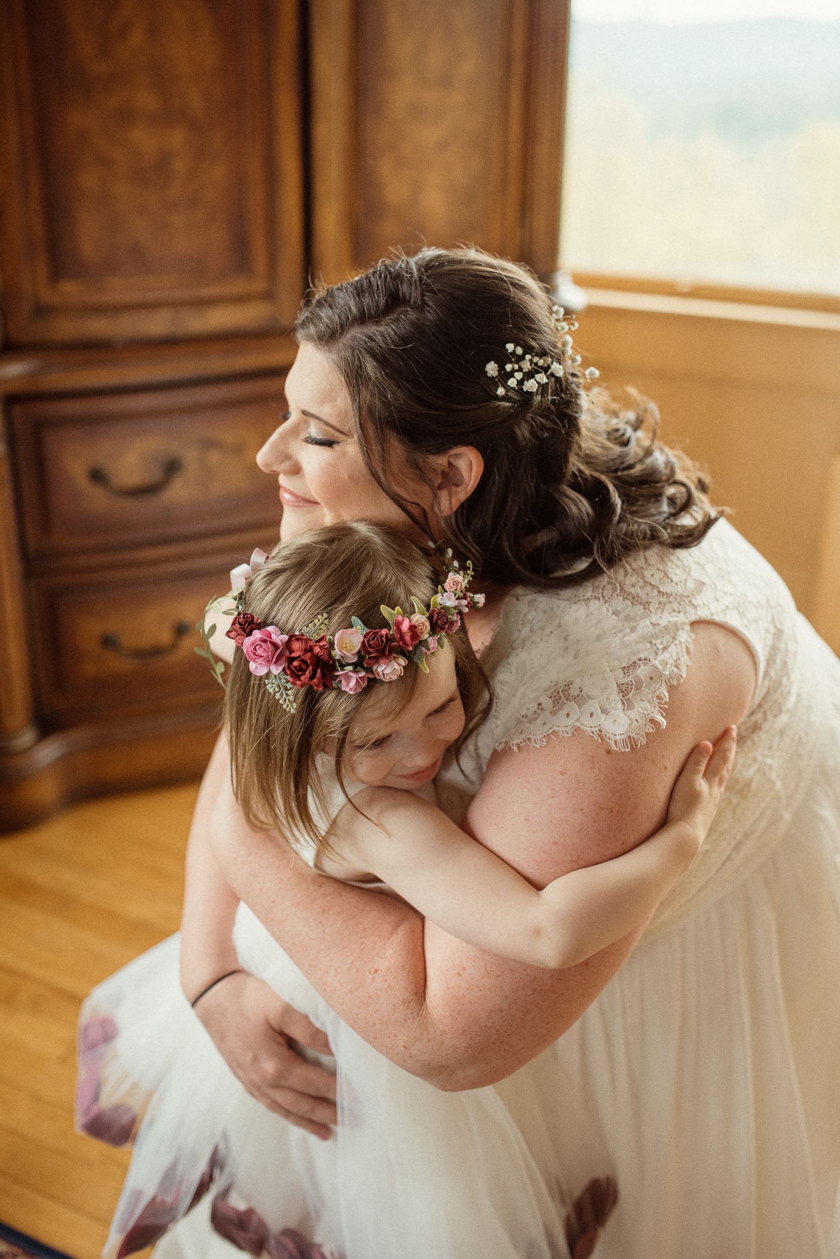Bride hugging her daughter during emotional moment before intimate North Carolina wedding.