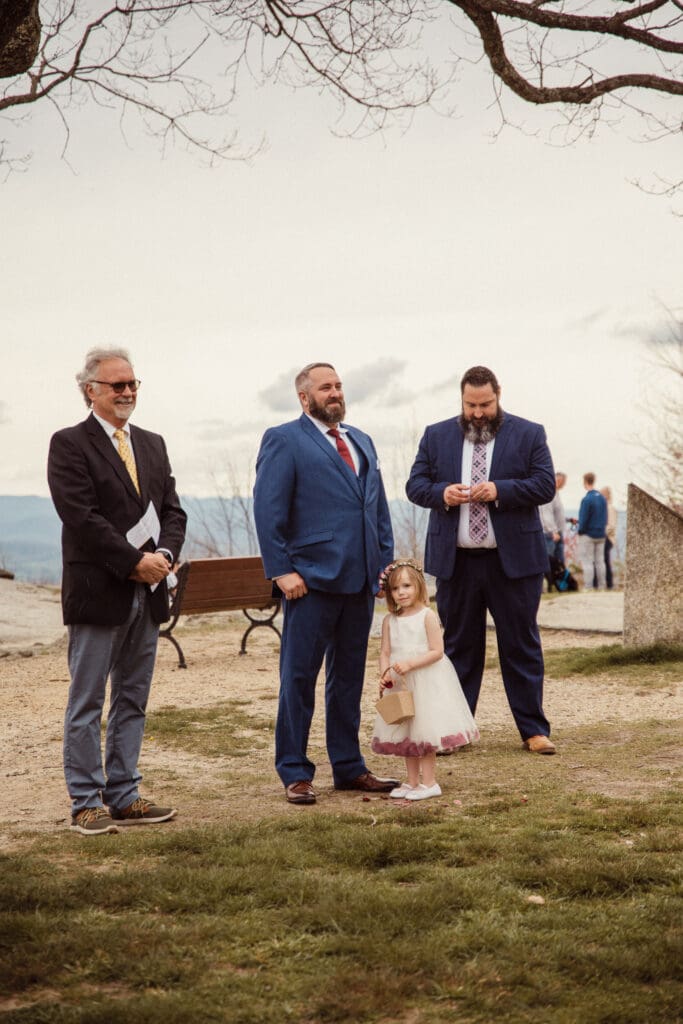 Wedding guests and flower girl waiting before ceremony at mountain overlook venue