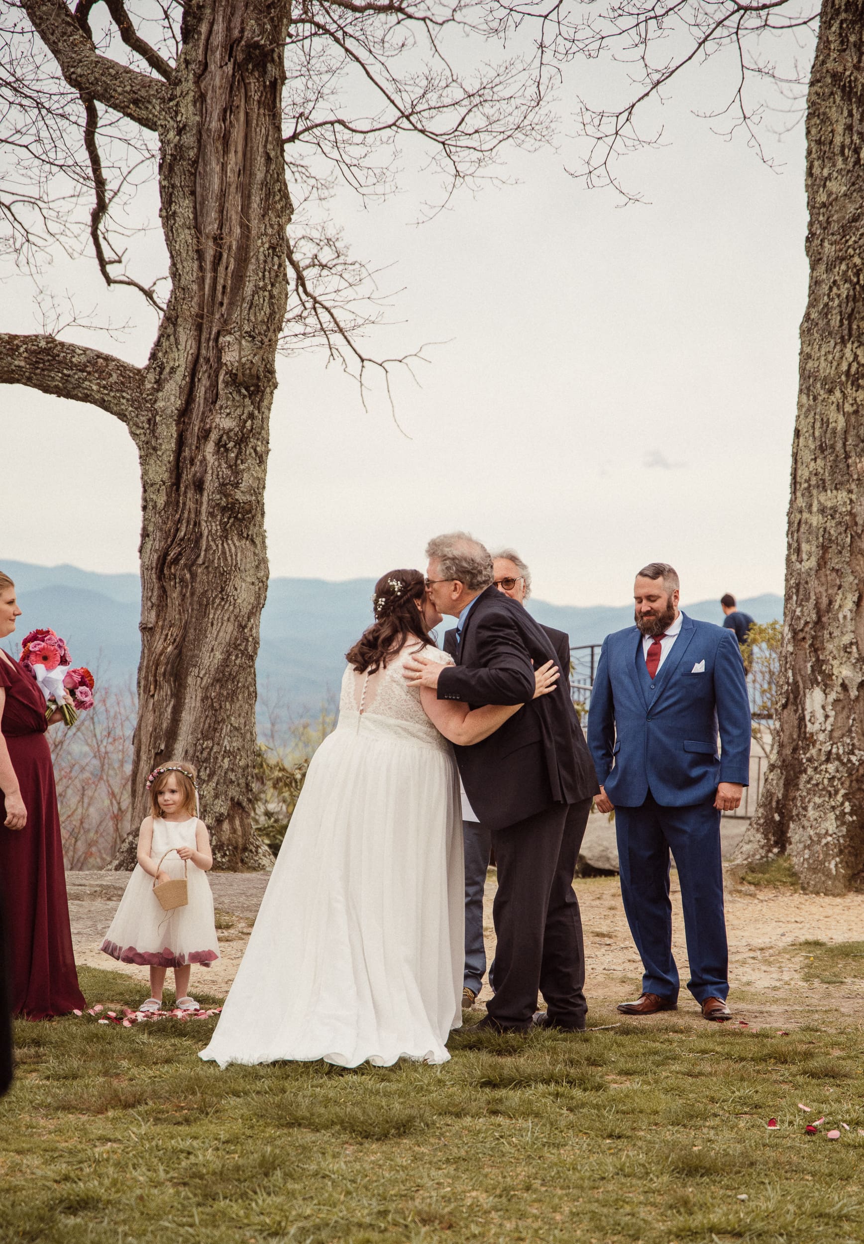 Bride hugging family member during emotional moment at mountain wedding ceremony