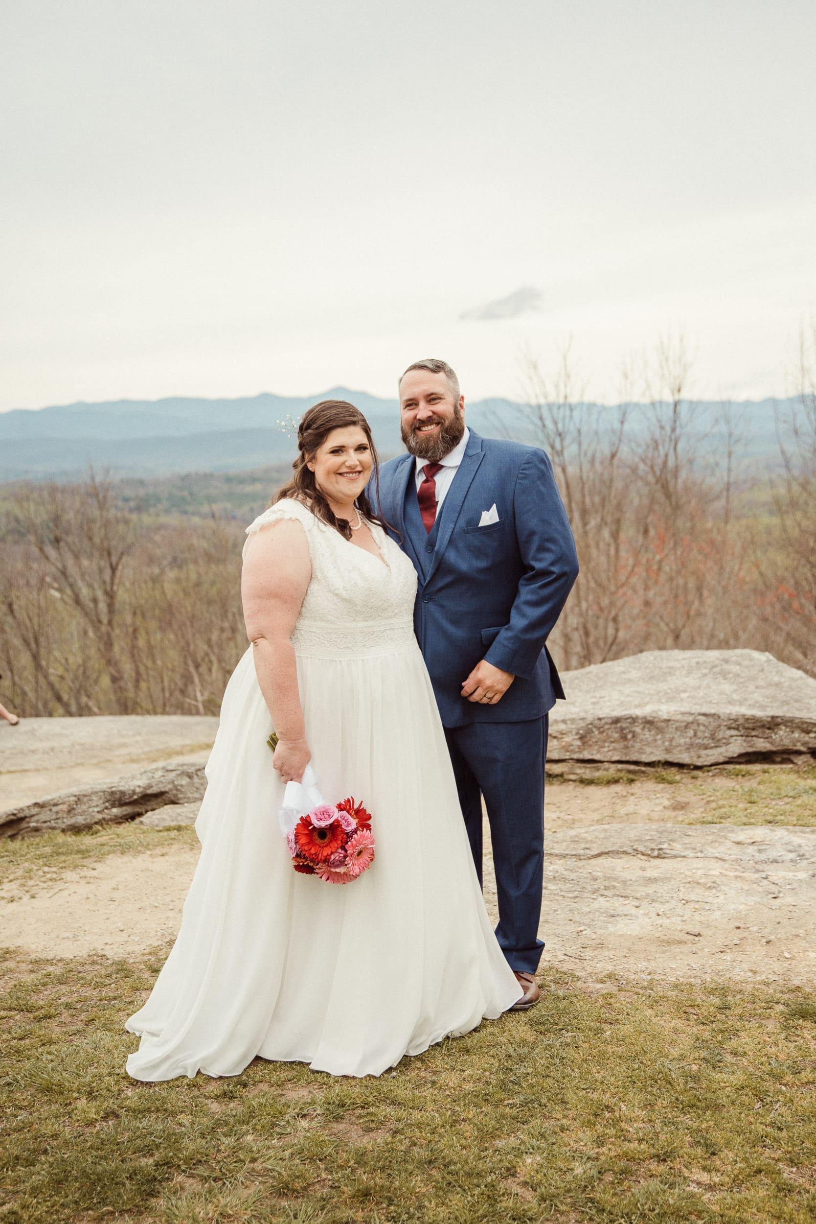 Bride and groom posing for portrait with Blue Ridge Mountains in background