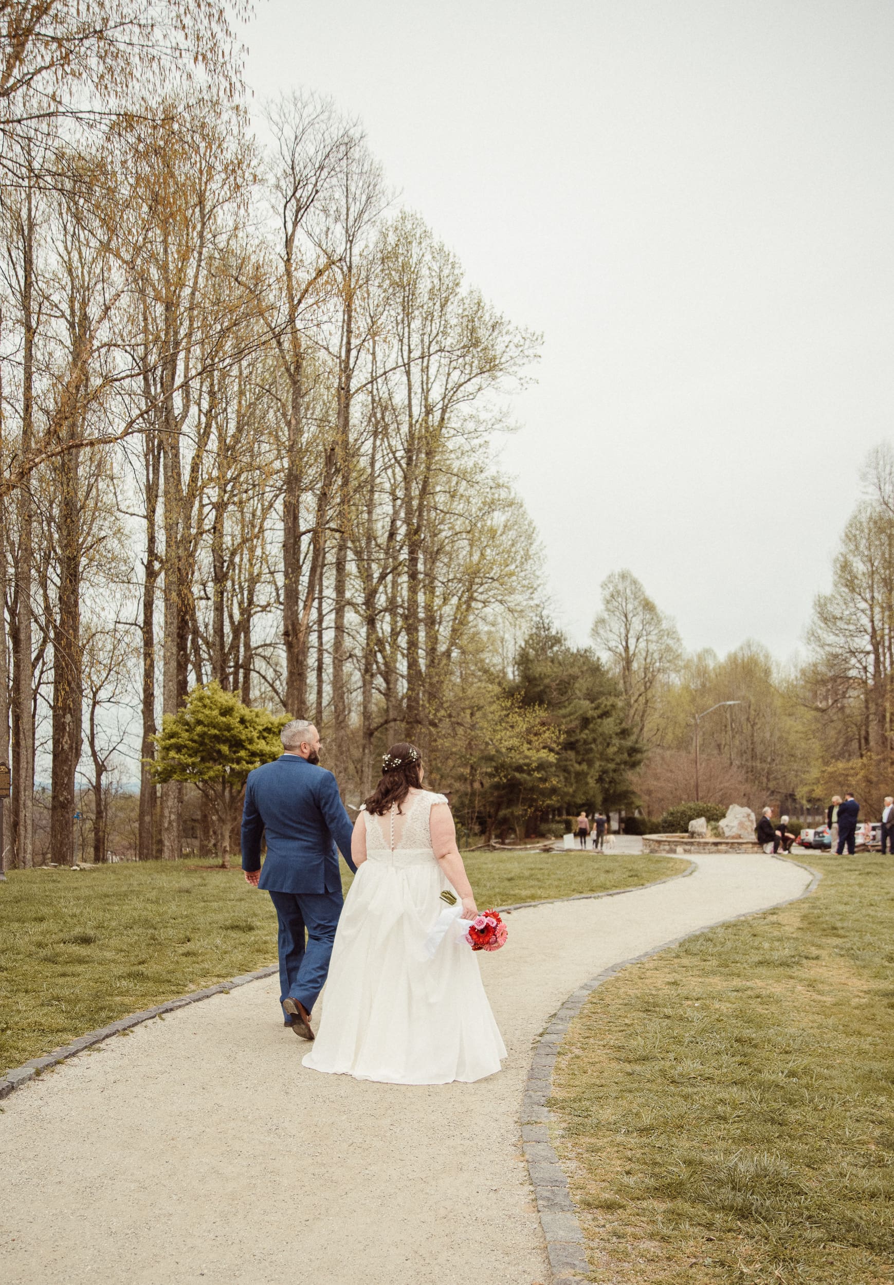 Newly married couple walking together down path after mountain wedding ceremony