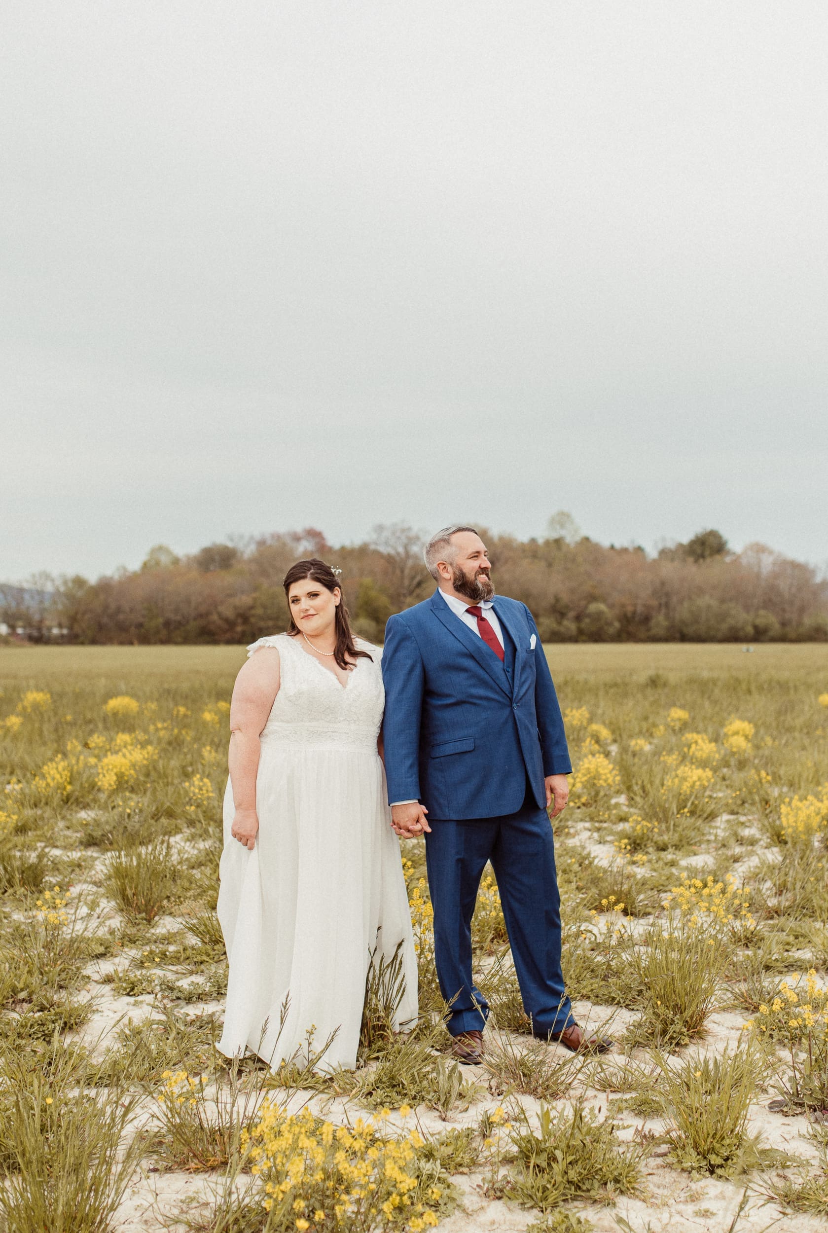 Bride and groom standing in wildflower field during North Carolina mountain wedding portraits