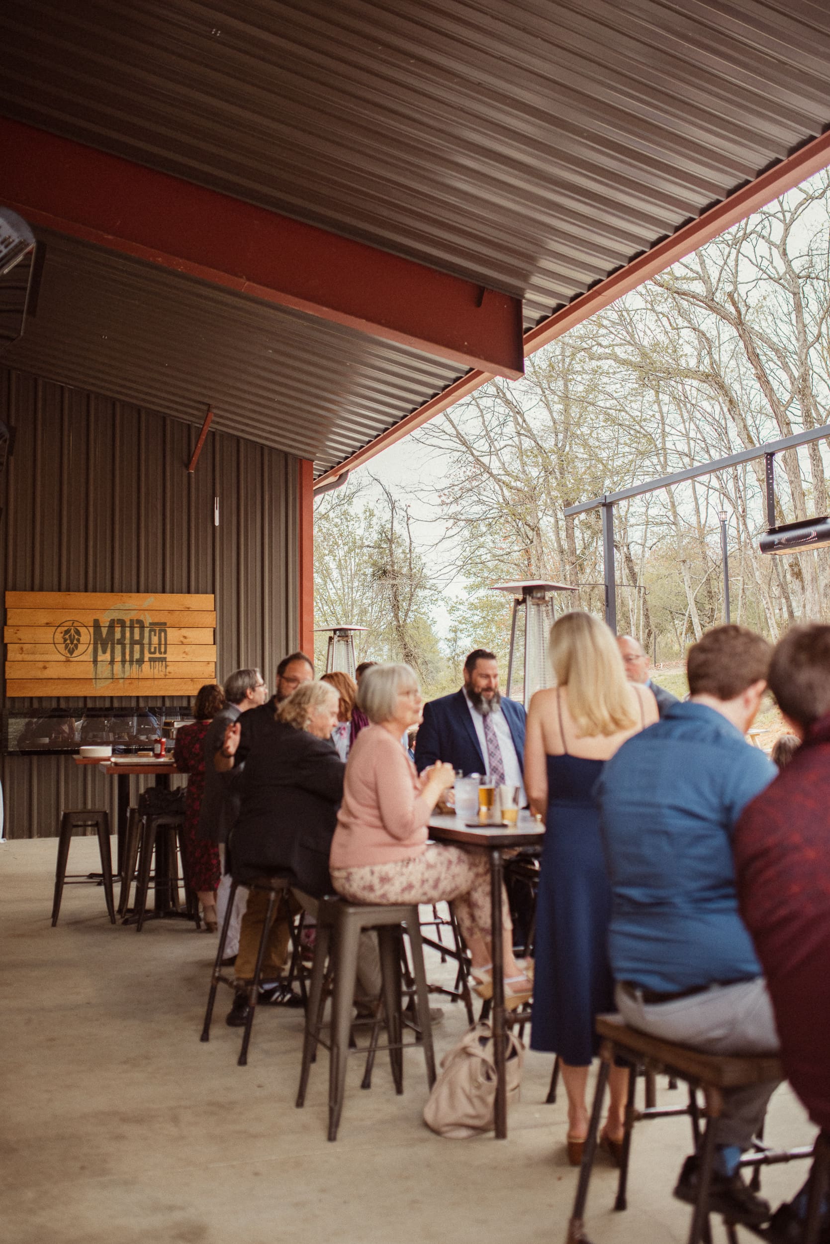 Guests celebrating at brewery during intimate wedding reception with casual atmosphere