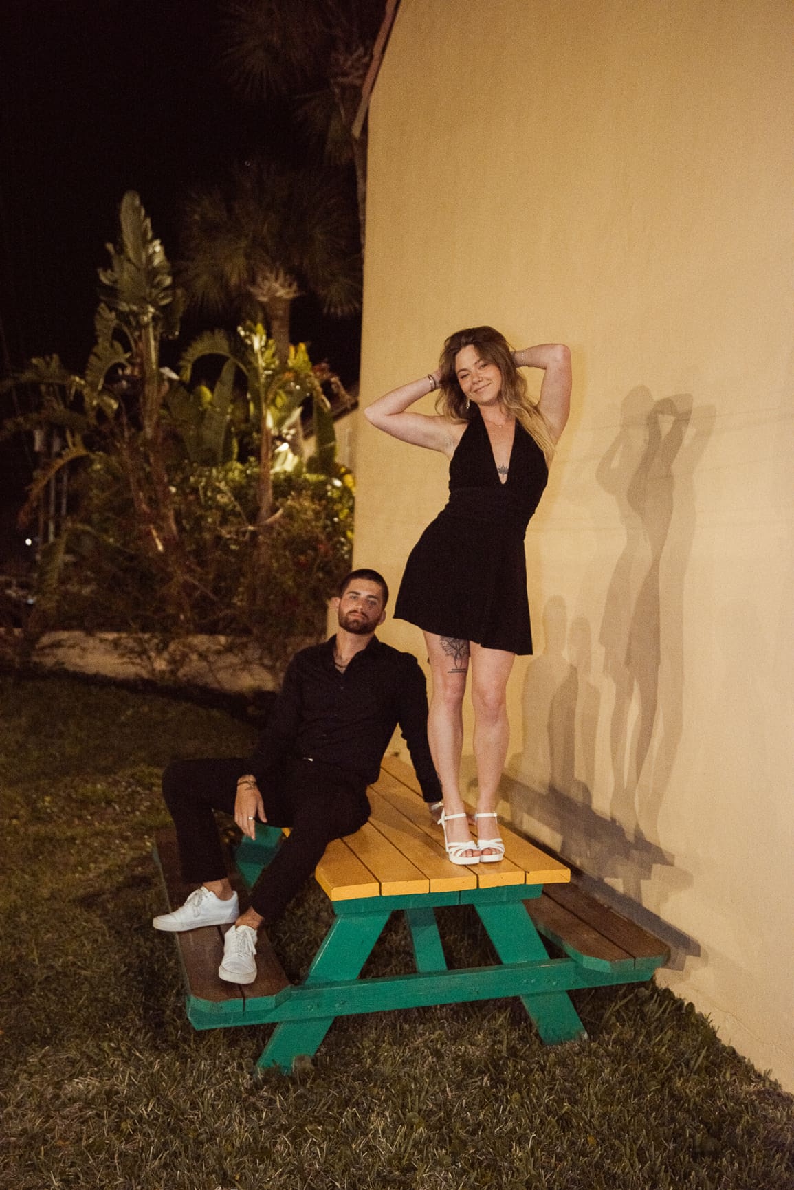 Couple styled in bold editorial outfits for engagement photos with structured fashion and dramatic posing