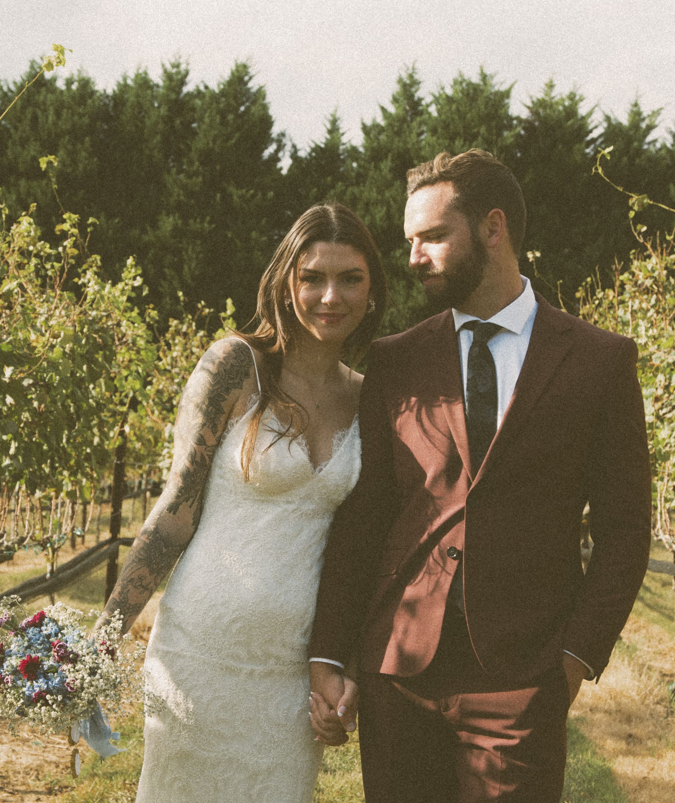 Romantic outdoor wedding portrait of a couple walking together during golden hour. 