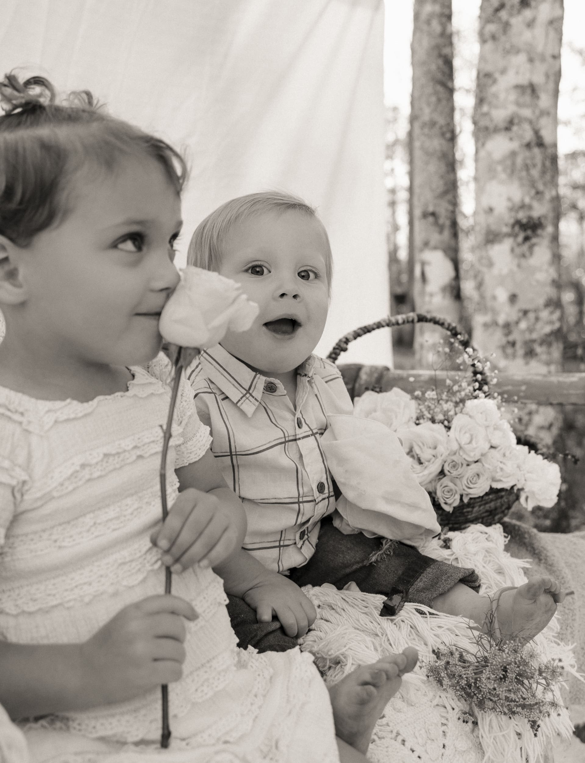 kids playing with flowers in backyard during in-home natural family session in north Florida