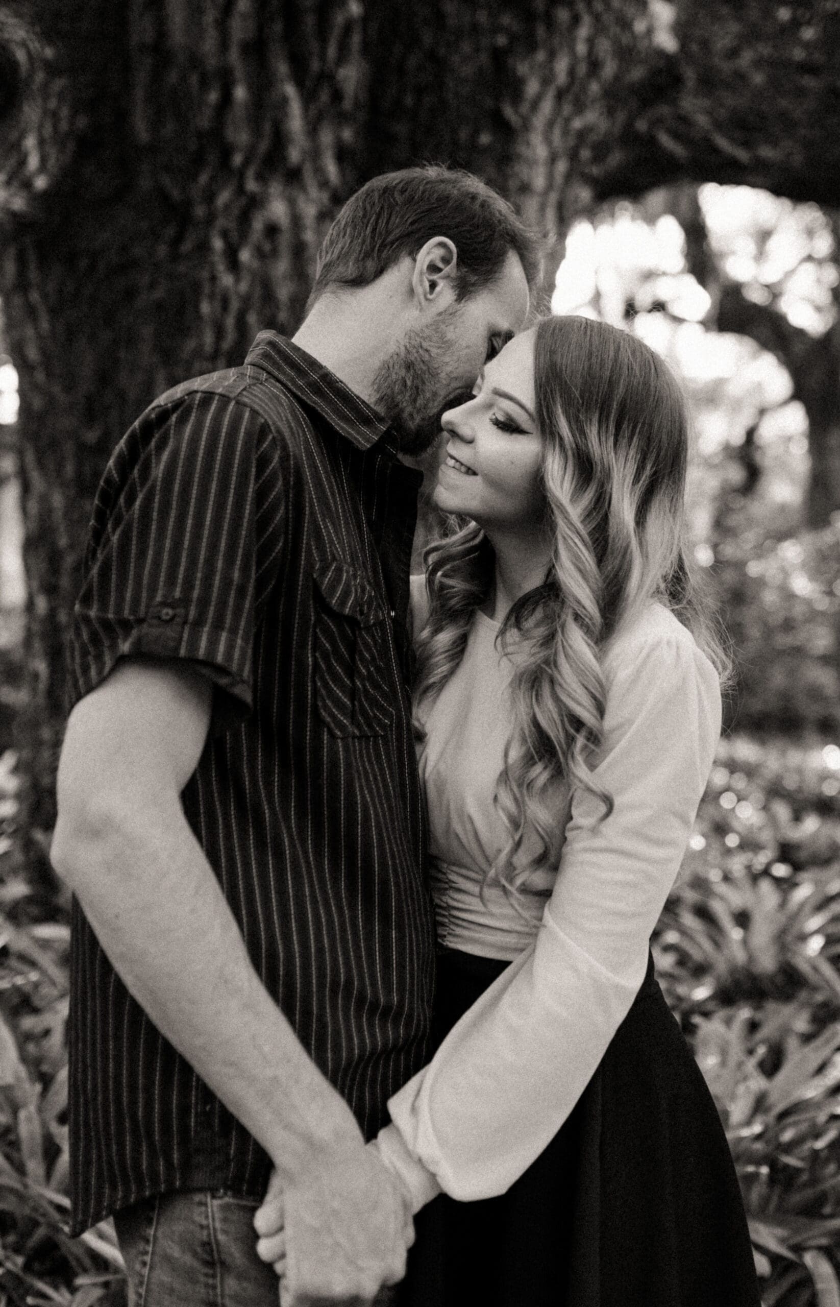 Couple holding each other closely in a romantic black and white engagement photo