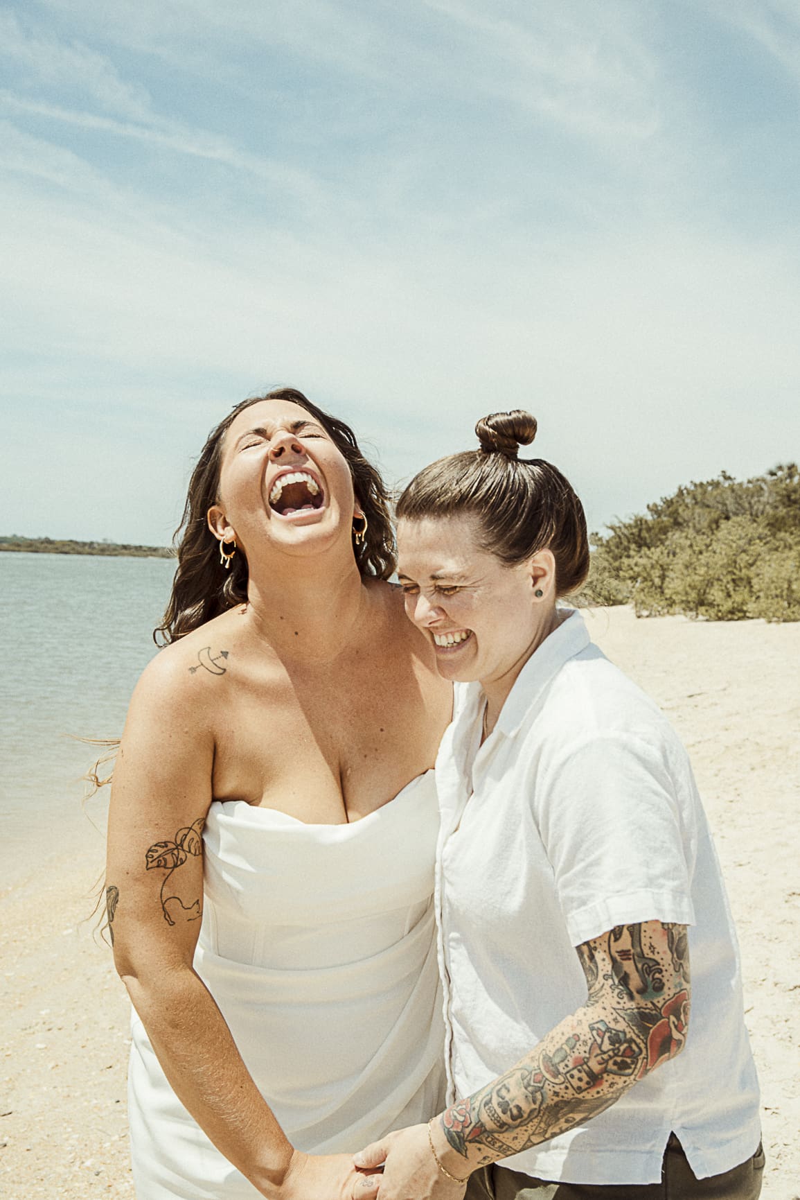 Couple laughing together on beach during Washington Oaks elopement in Florida